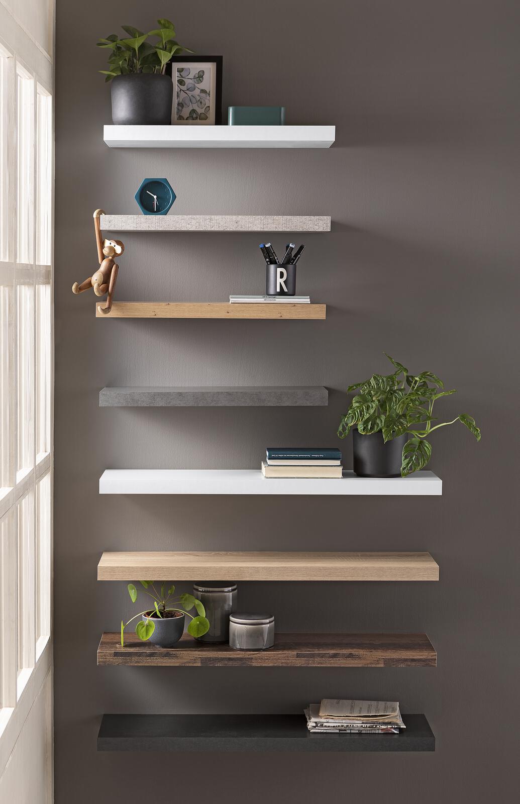 Wand mit mehreren schwebenden Wandboards in Weiß und Asteiche-Optik  dekoriert mit Pflanzen  Büchern und Accessoires