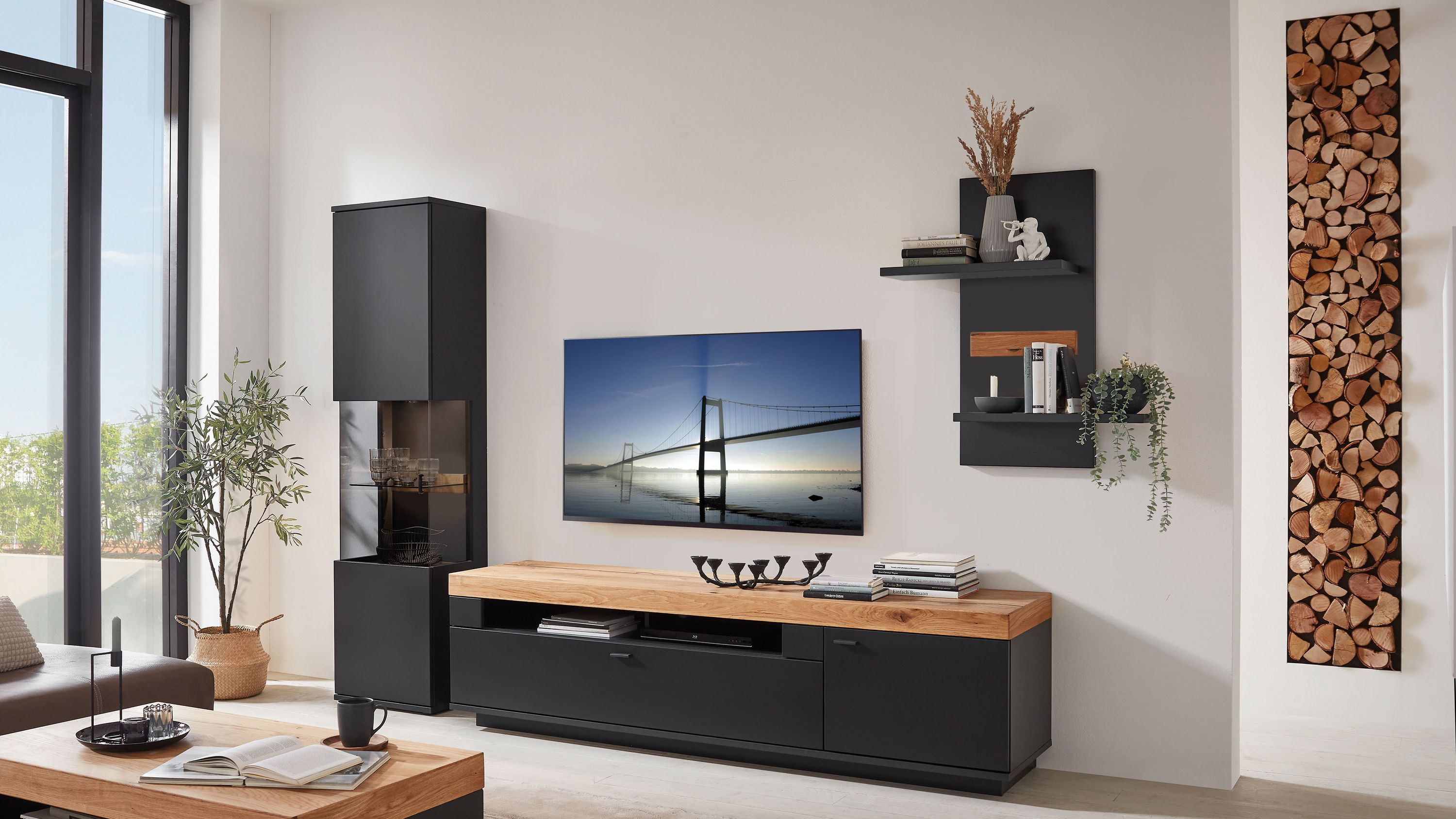 Dreiteilige Wohnwand mit schwarzem Korpus und hellbrauner Ablage: TV-Element, hoher Schrank und Wandregal