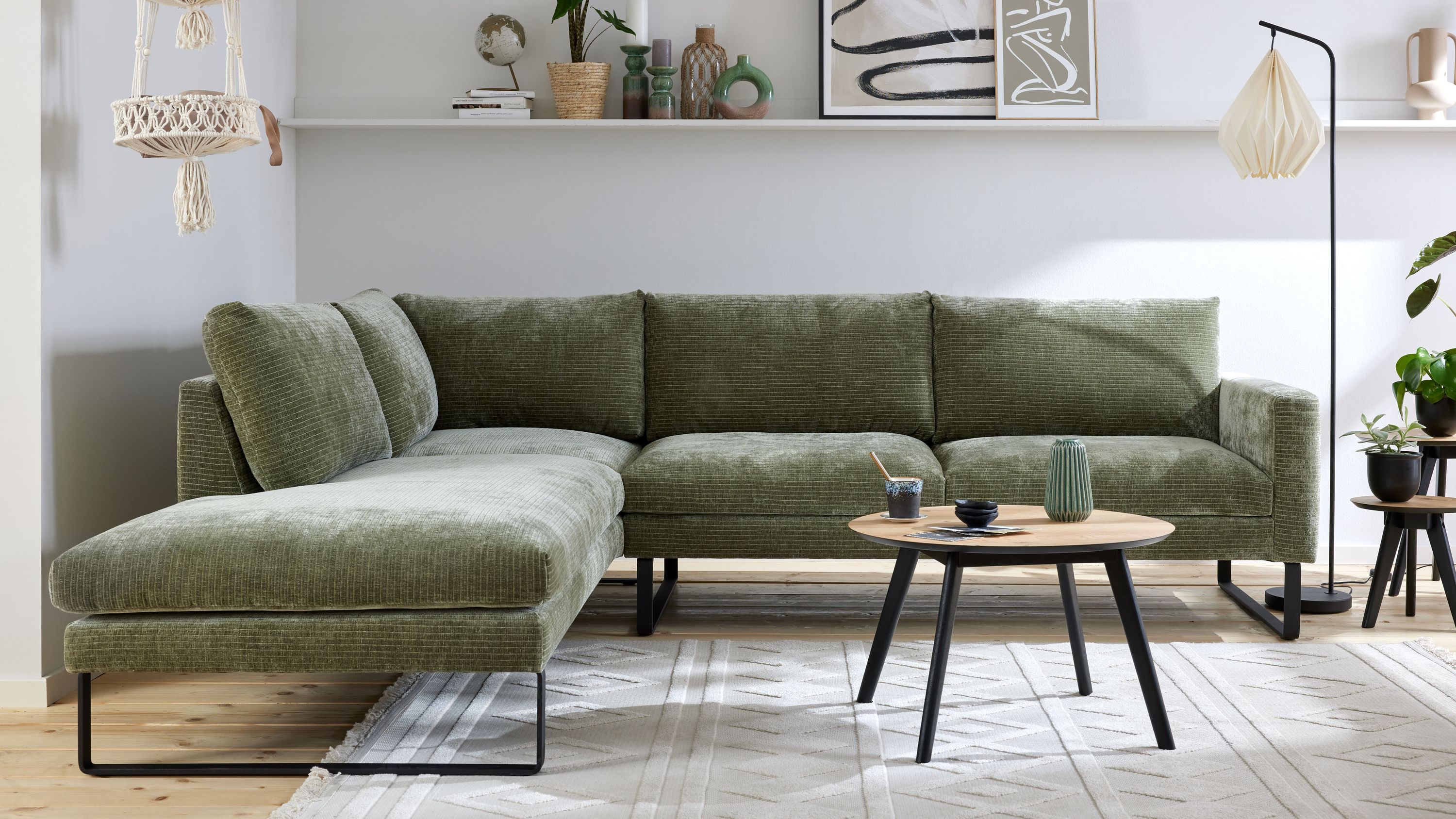Ecksofa mit schildkrötenfarbenem Bezug und schwarzen Kufenfüßen Ecksofa mit schildkrötenfarbenem Bezug und schwarzen Kufenfüßen in modernem Wohnzimmer