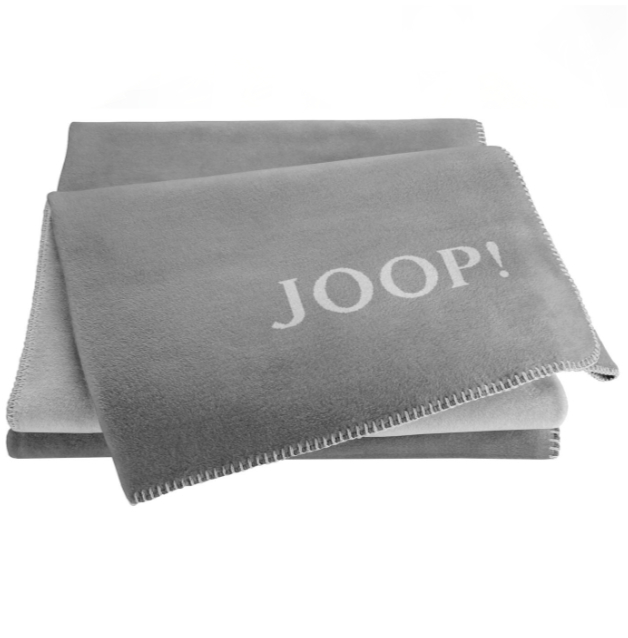 Gefaltete graue Decke, obere mit weißem „JOOP!“-Schriftzug, ordentlich gestapelt, frontal aufgenommen