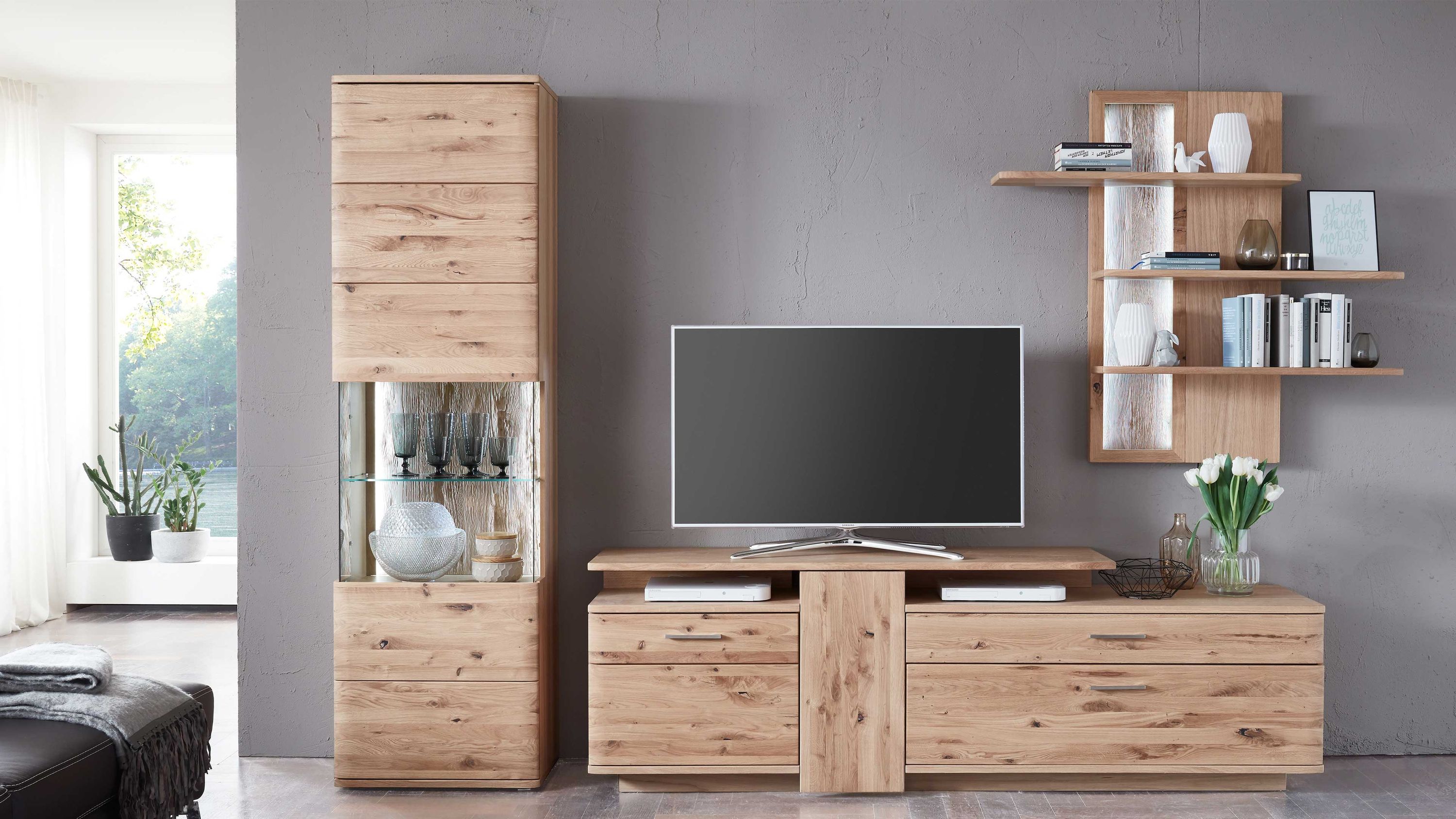 Dreiteilige Wohnwand aus hellem Holz mit Vitrine TV-Board und Wandregal an grauer Wand