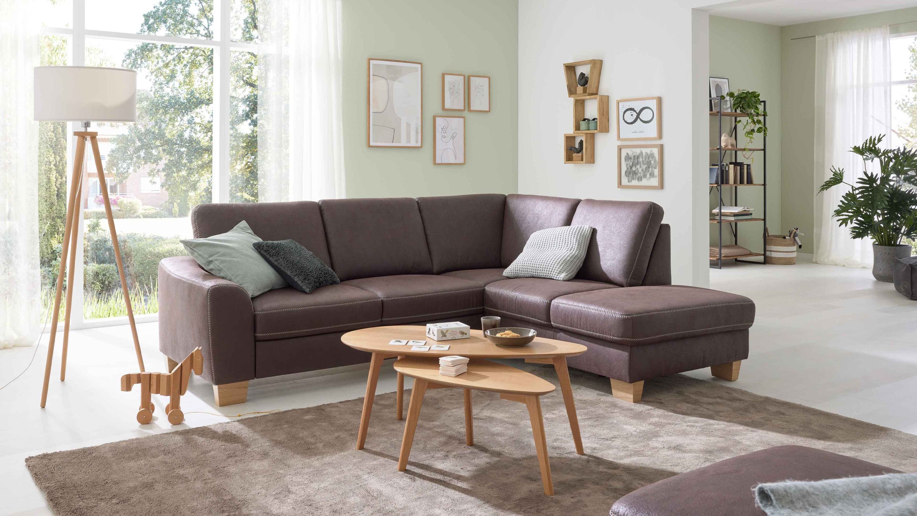 Ecksofa mit moccafarbener Mikrofaser und Holzfüßen in modernem Wohnzimmer mit Teppich und Holztischen