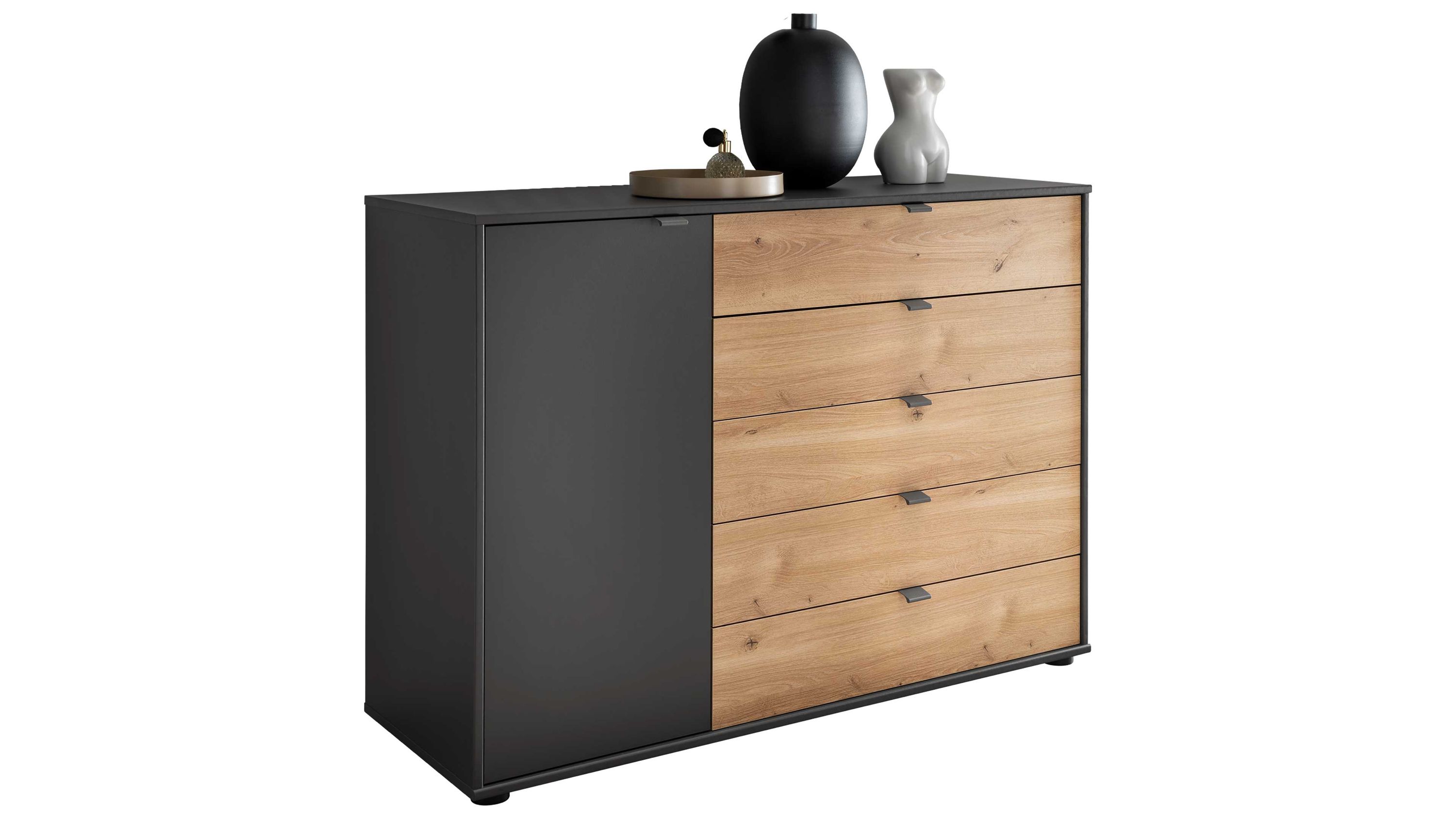Kombikommode mit Schubladen und Tür in Holz- und Dunkelfarben Kombikommode mit fünf Schubladen in Holzoptik und einer Tür in dunkler Farbe mit Dekoration