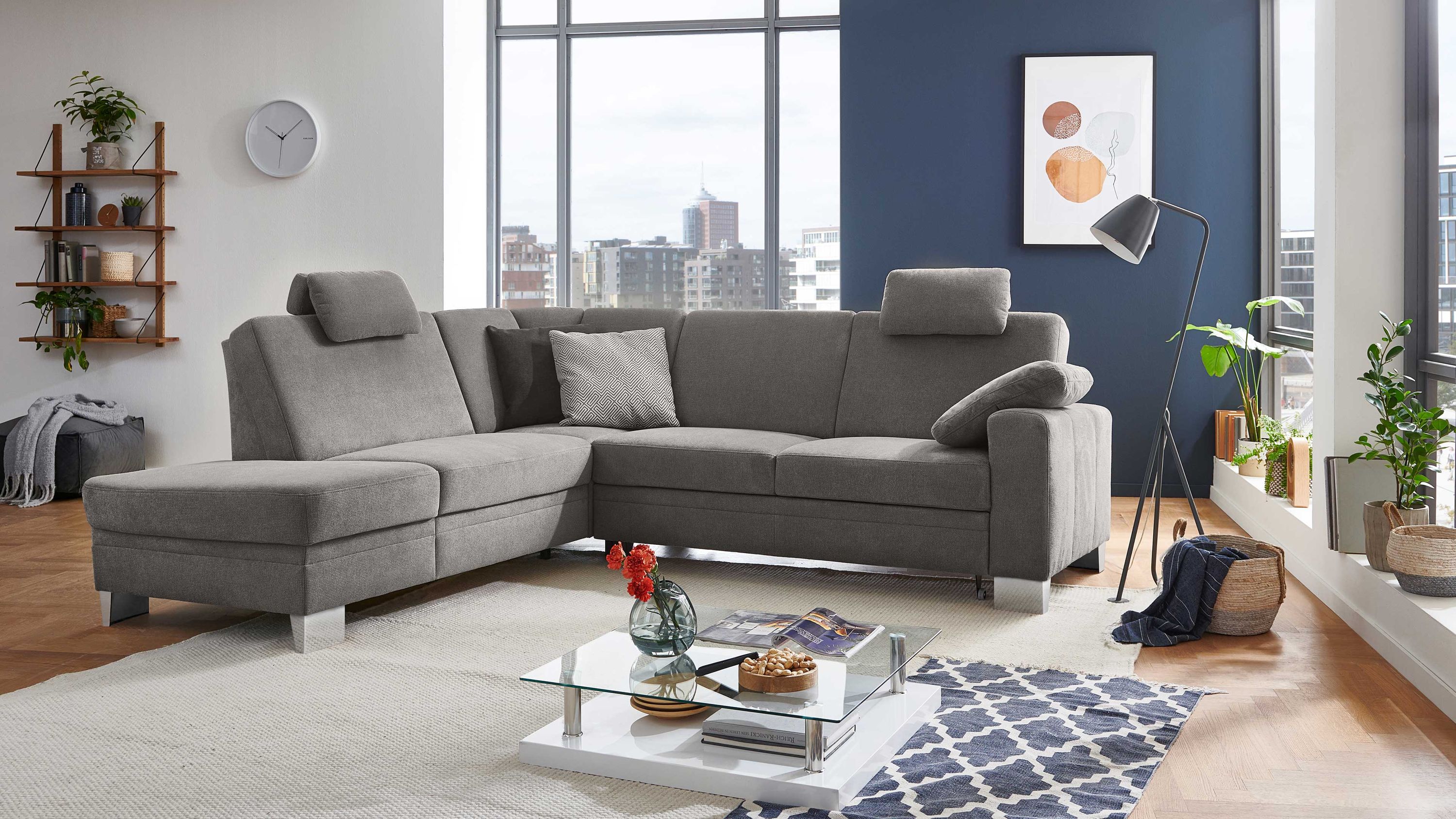 Ecksofa mit grauem Bezug verstellbaren Kopfstützen und silberfarbenen Füßen in modernem Wohnzimmer