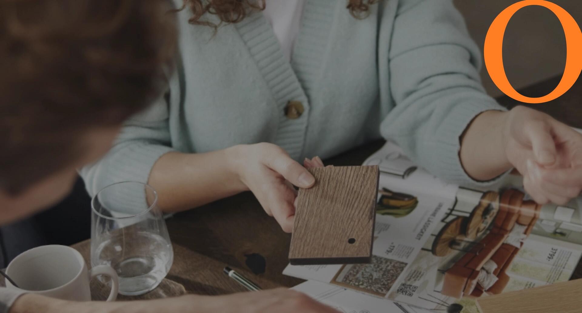 Materialberatung mit Holzmustern und Einrichtungskatalogen, gemeinsame Planung individueller Wohn- und Objektlösungen.
