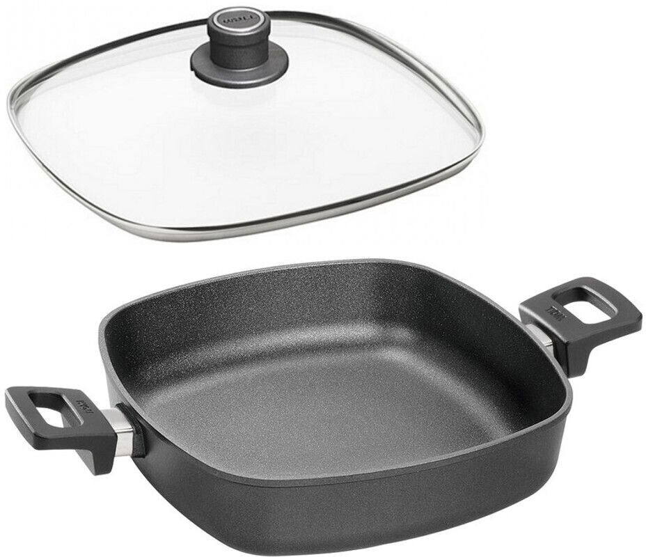 Schwarze quadratische Bratpfanne mit Griffen und Glasdeckel leicht erhöht von links aufgenommen auf heller Fläche