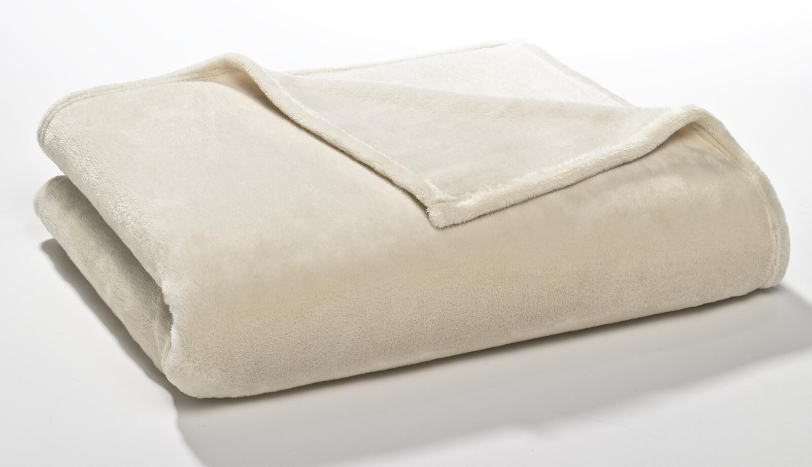 Gefaltete cremefarbene Kuscheldecke mit flauschiger Oberfläche  freigestellt fotografiert