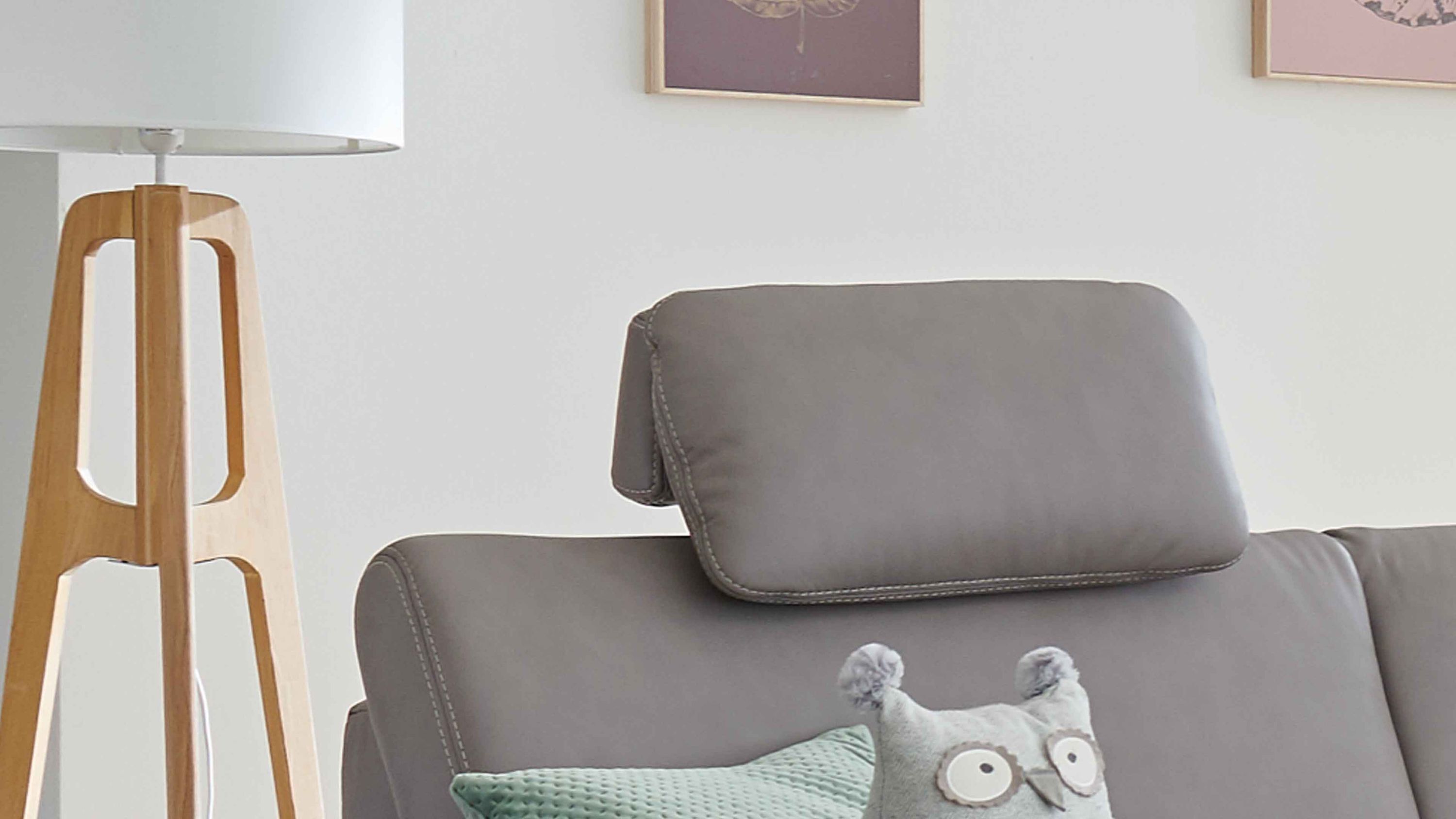Kopfstütze in grauer Farbe auf grauem Sofa mit sichtbaren Nähten