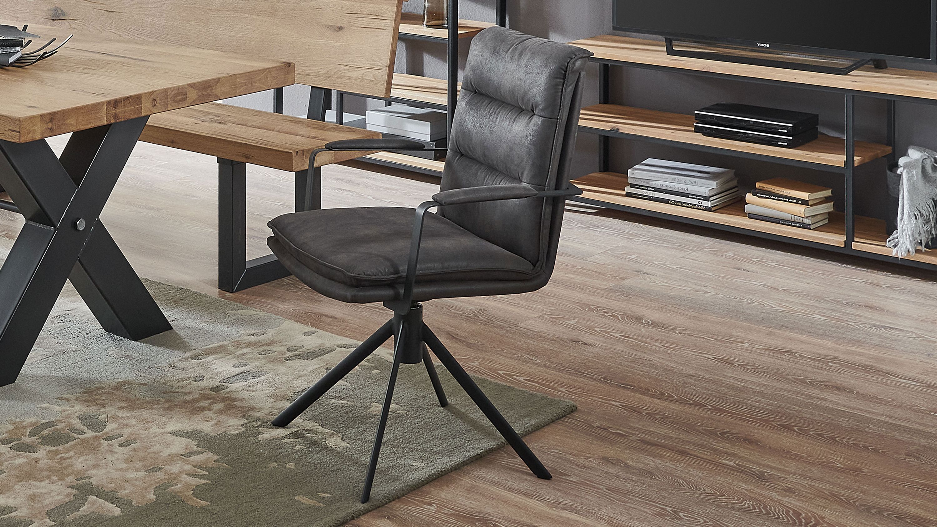 Armlehnstuhl mit Drehfunktion in Anthrazit und Schwarz Anthrazitfarbener Armlehnstuhl mit gepolsterter Rückenlehne und Sitzfläche auf schwarzem Drehgestell