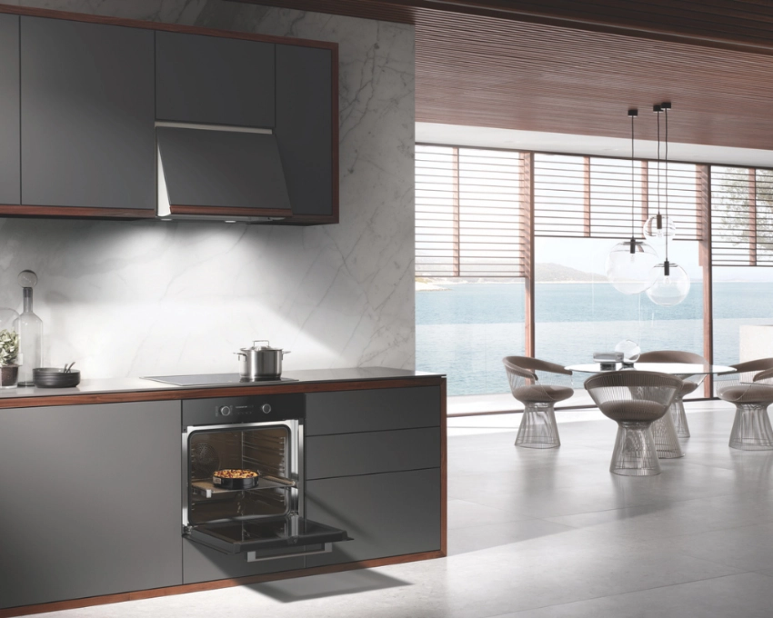 Miele Komplettküche mit integriertem Dampfgarer Offene Küche in dunkler Optik mit Dampfgarer und Dunstabzugshaube in modernem Wohnambiente