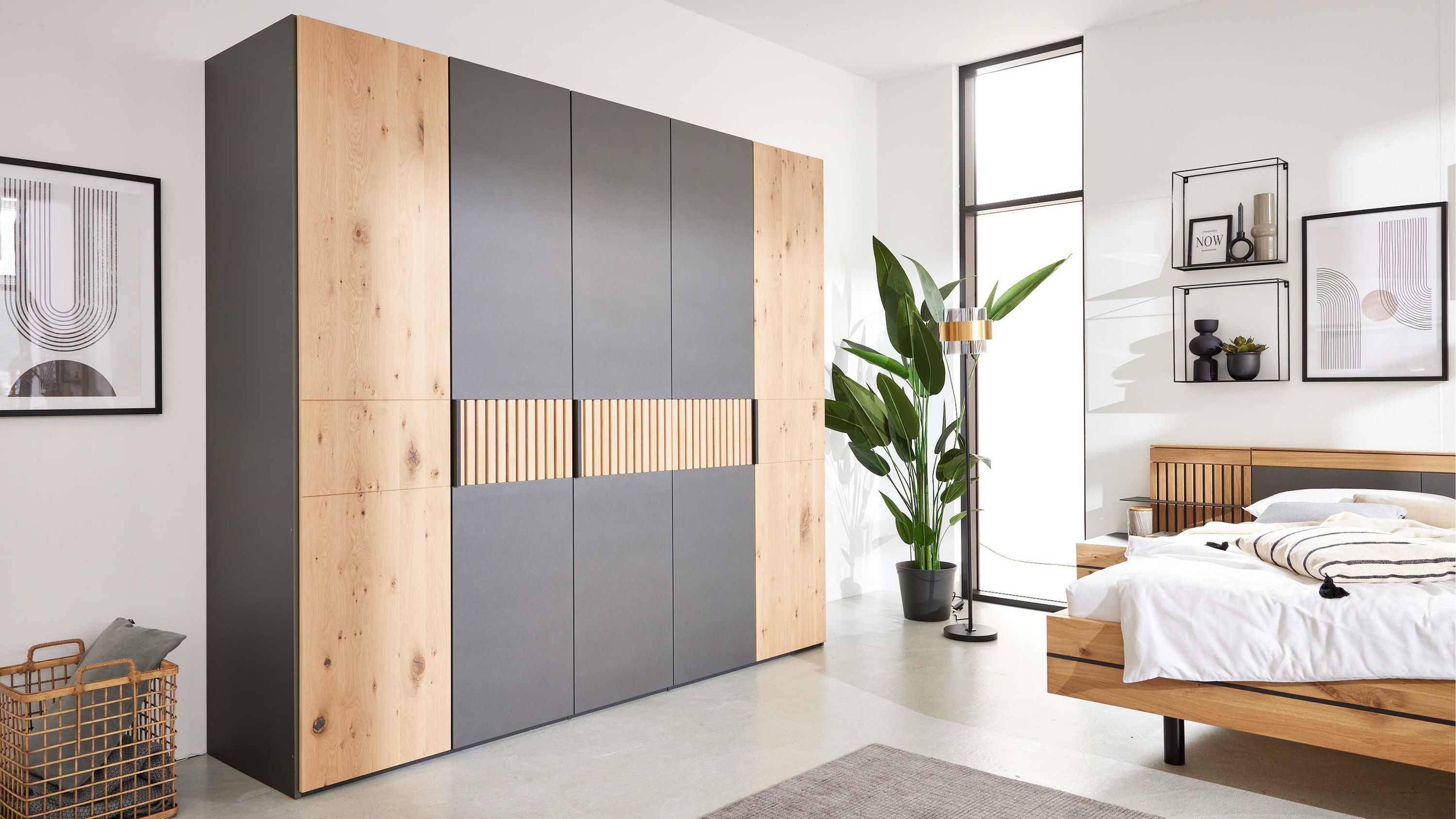 Fünftüriger Kleiderschrank mit Fronten in Holzoptik und grauen Flächen in modernem Schlafzimmer