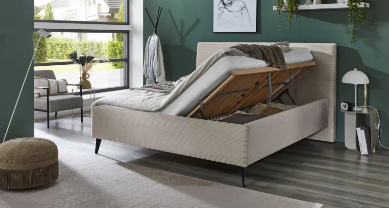 Matratzen Modernes Polsterbett mit hochgeklappter Matratze und integriertem Bettkasten, grüner Wandfarbe und großen Fenstern im Schlafzimmer.