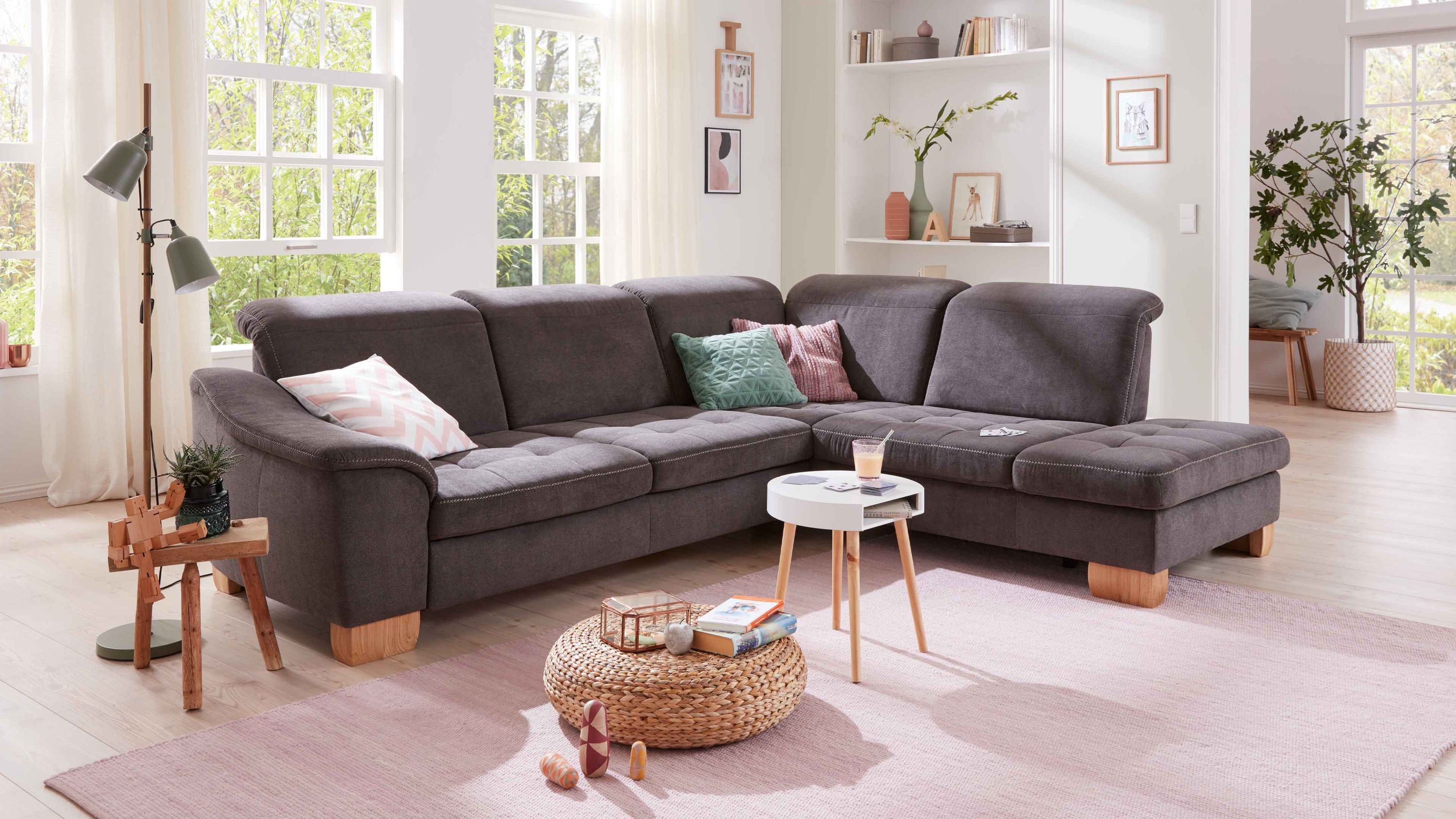 Ecksofa mit schieferfarbenem Bezug und Holzfüßen Ecksofa mit schieferfarbenem Bezug und Holzfüßen in hellem Wohnzimmer mit Fenster