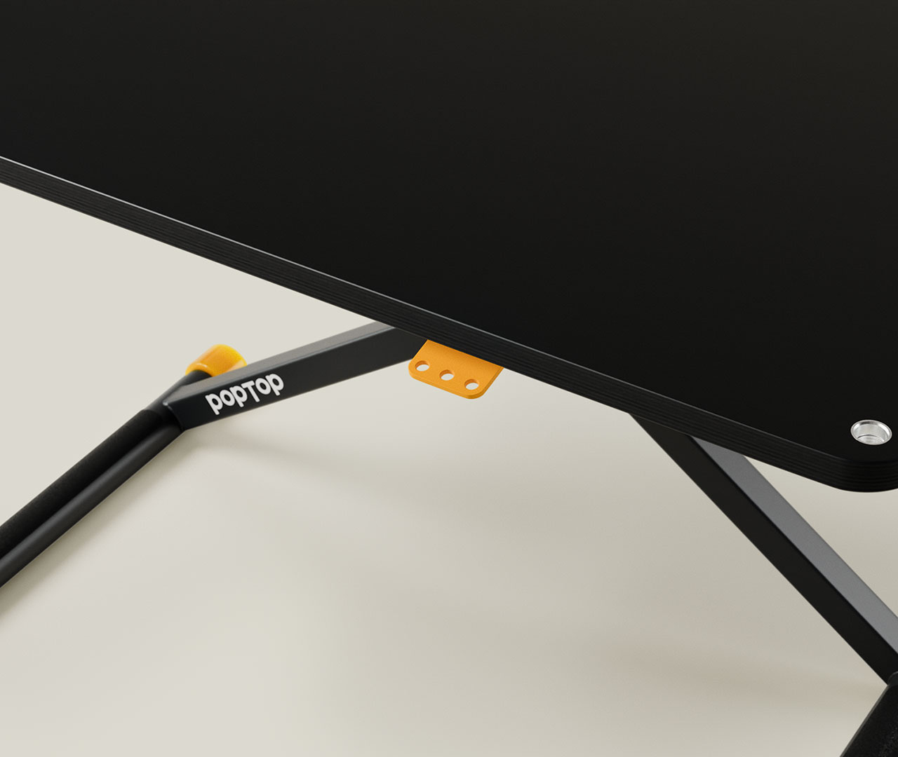 Nahaufnahme eines schwarzen Schreibtischs mit orangefarbenem Hebel unter der Tischplatte und sichtbarem Gestell.