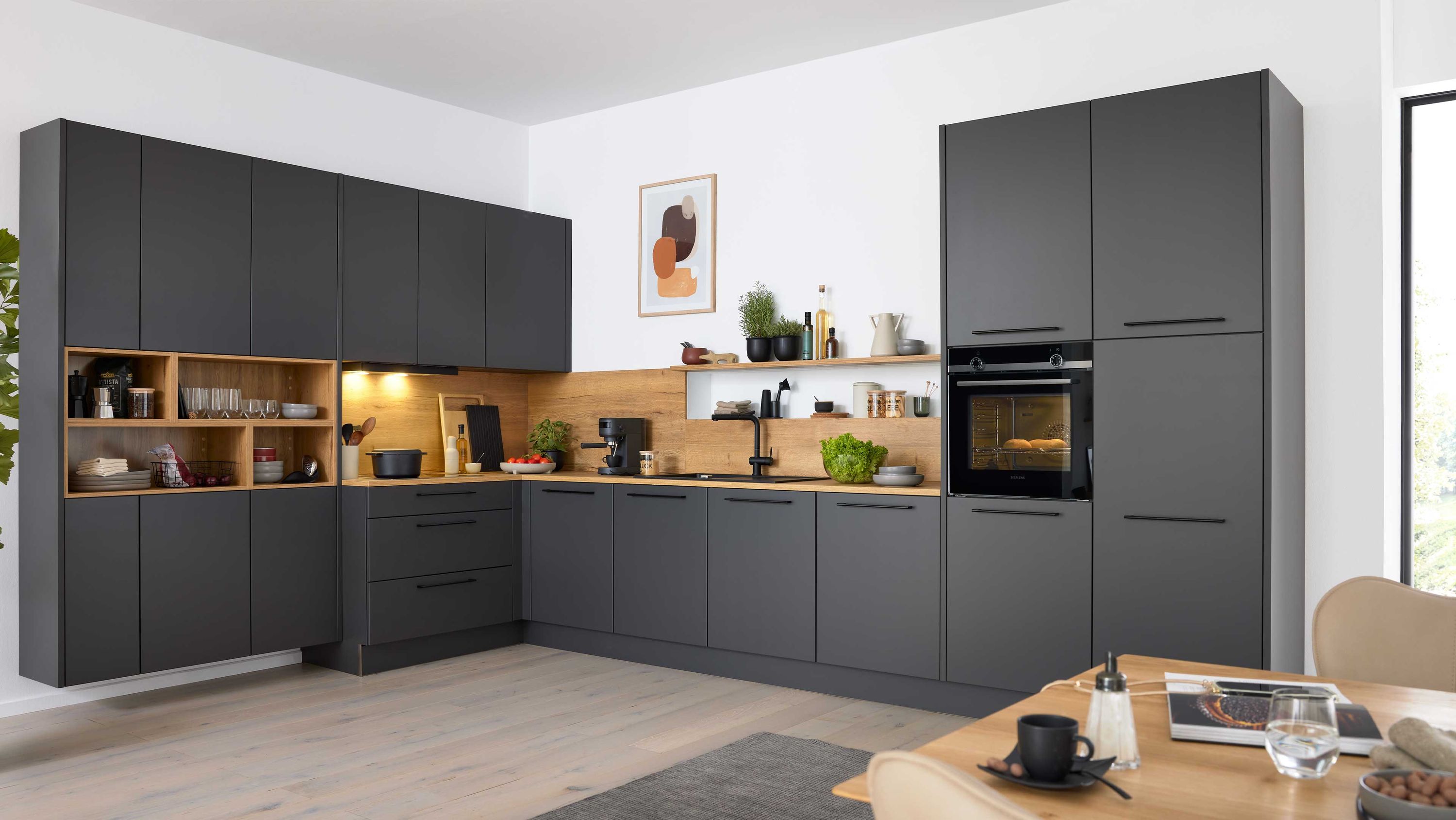 Dunkelgraue L-Küche mit Holzarbeitsplatte. Dunkelgraue L-Küche mit Holzarbeitsplatte offenen Regalfächern Einbauofen und heller Wandgestaltung.