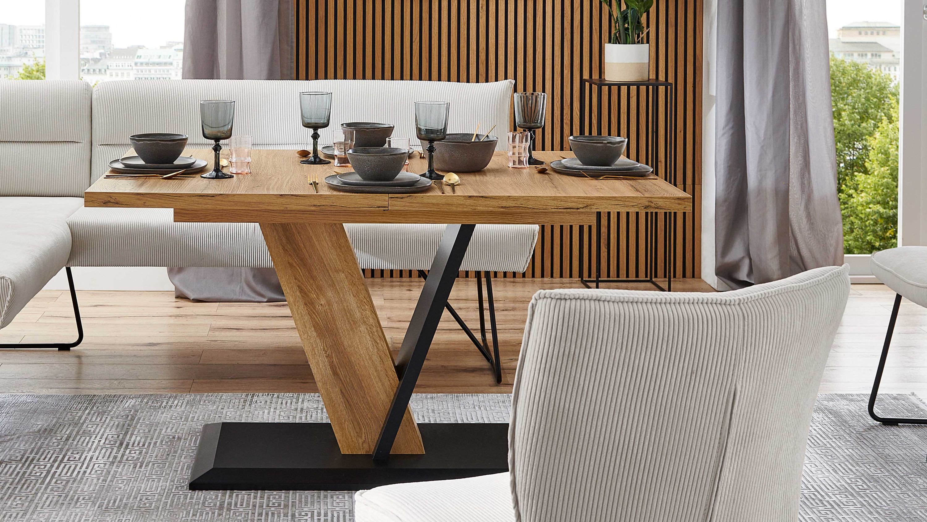 Ausziehtisch mit Holzplatte und schwarzem Gestell Ausziehtisch mit rechteckiger Holzplatte und schwarzem Metallgestell in modernem Esszimmer