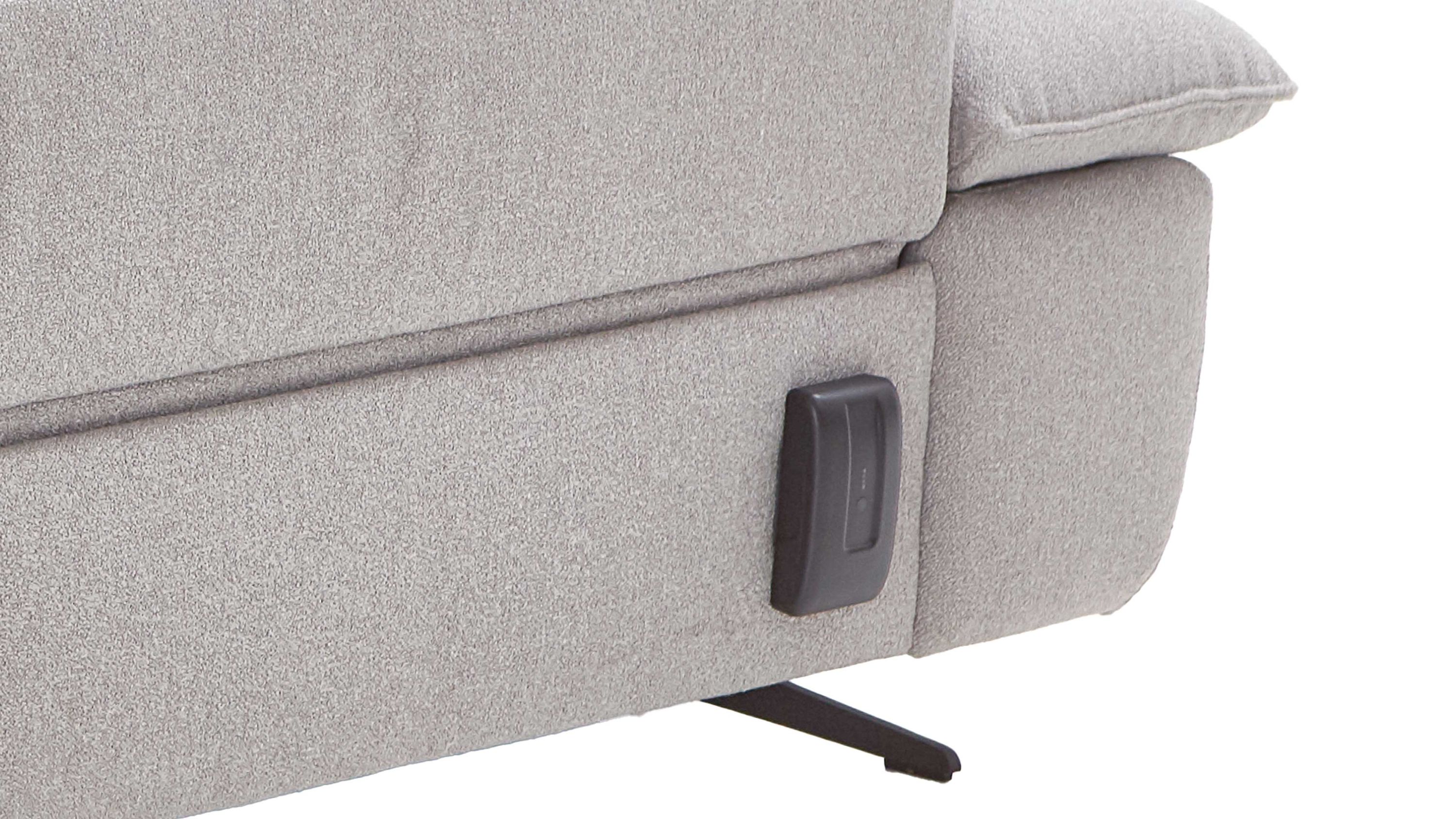 Schwarzer Akku an grauem Polstersofa unten seitlich