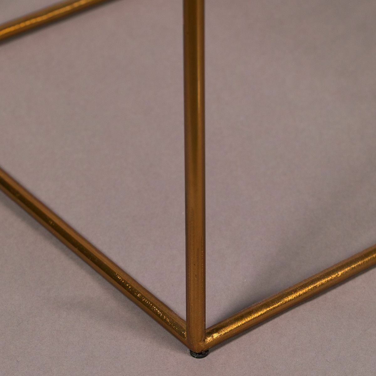 Ecke eines goldenen Metallgestells Nahaufnahme einer Ecke eines goldenen Metallgestells auf grauem Hintergrund