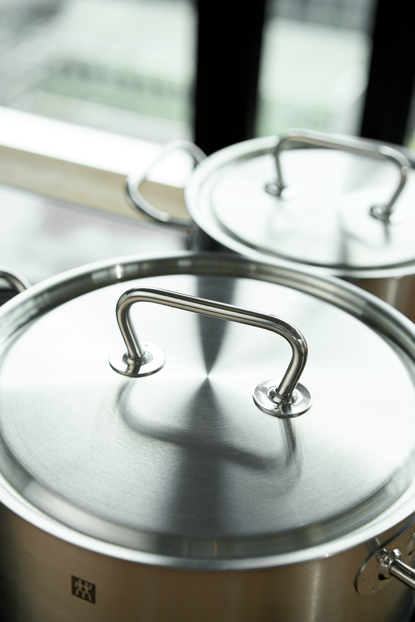 Edelstahl-Topfdeckel mit massivem Metallgriff gebürstete Oberfläche Detailansicht eines Kochtopfs