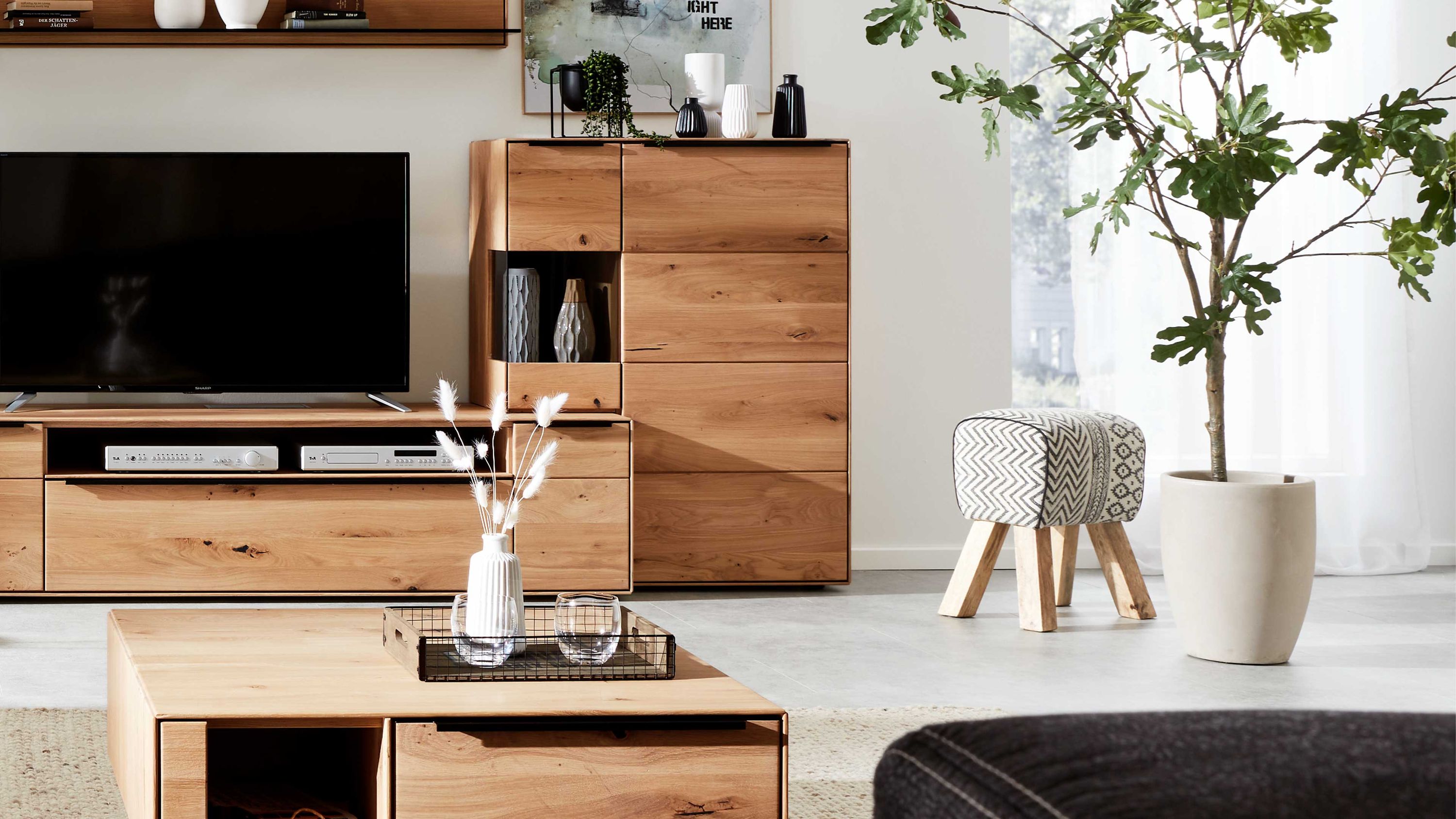 Helles Highboard mit zwei Türen und offenem Fach aus Holz mit sichtbarer Maserung in einem Wohnzimmer