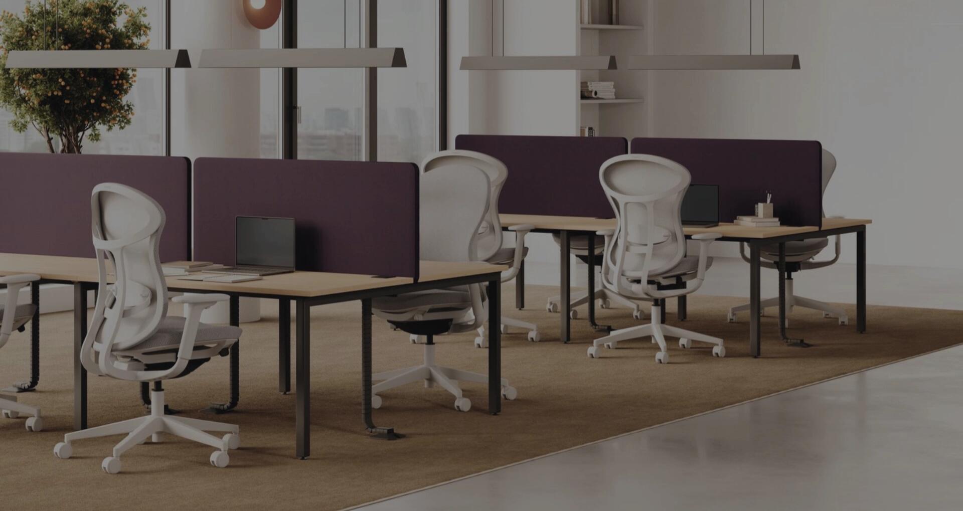 Modernes Großraumbüro mit Schreibtischen, ergonomischen Bürostühlen, Sichtschutzwänden und heller Arbeitsplatzbeleuchtung.