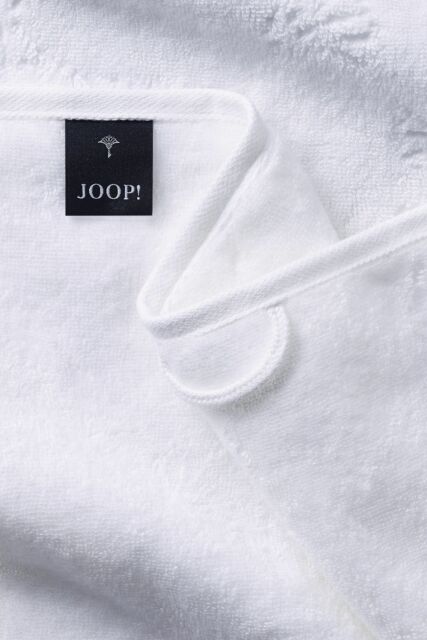 Weißes Handtuch mit „JOOP!“-Label und feiner Textur Weiße, gefaltete Handtuch-Detailaufnahme mit schwarzem „JOOP!“-Label und sichtbarer Stoffstruktur