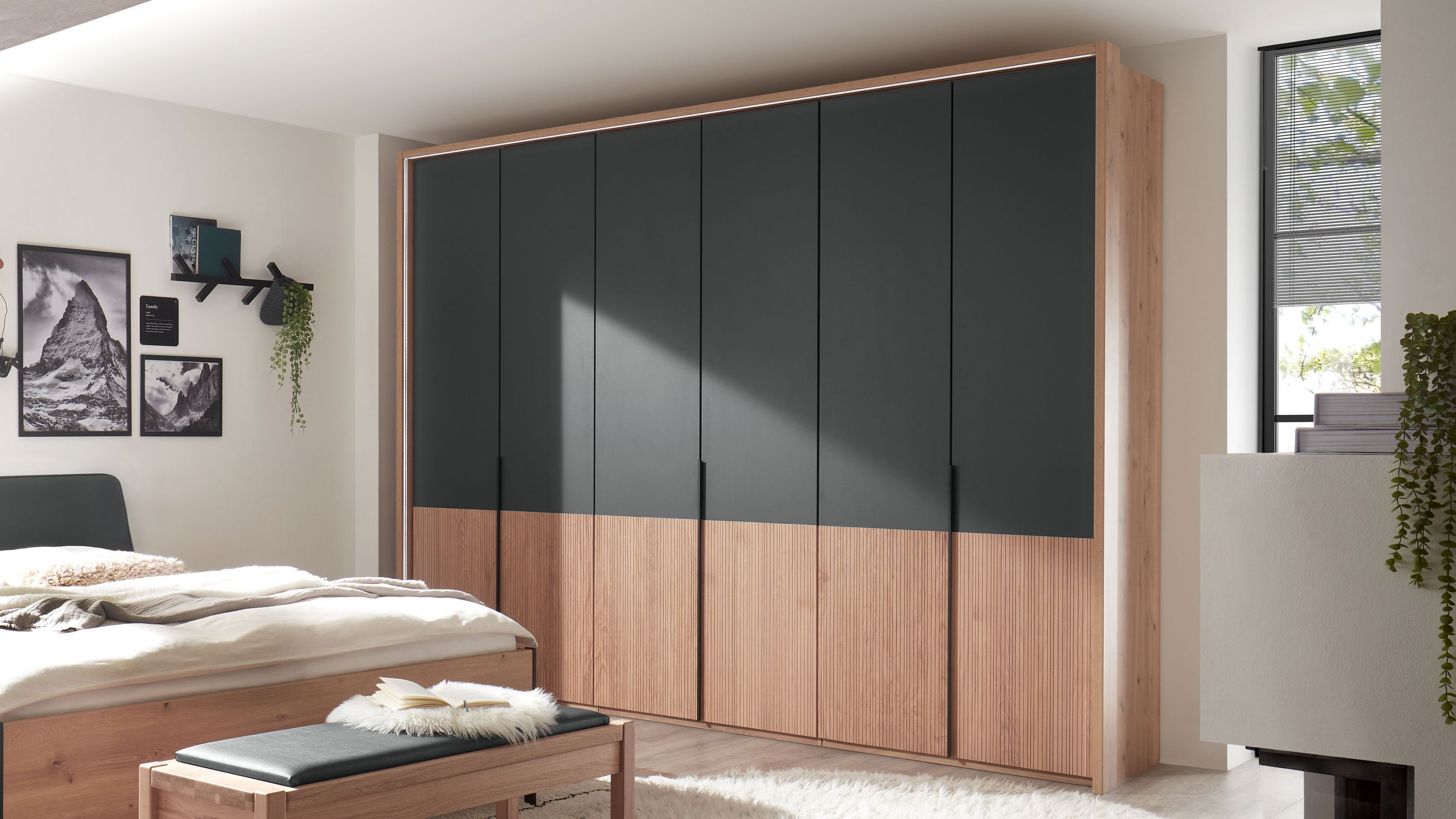 Sechstüriger Kleiderschrank mit grauen und holzfarbenen Fronten in einem Schlafzimmer