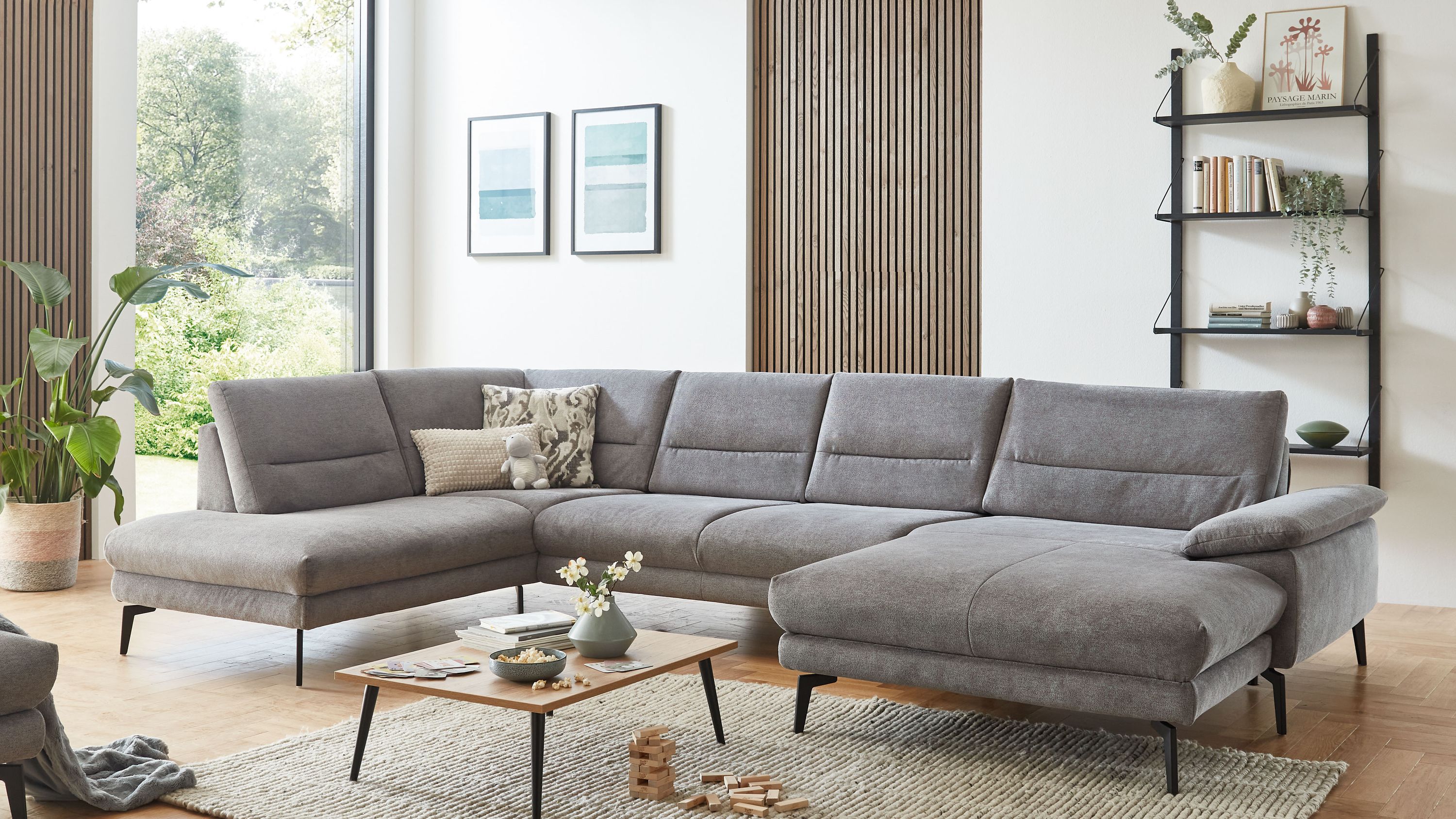 Großzügige graue Wohnlandschaft mit Flachgewebe und schwarzen Metallfüßen in modernem Wohnzimmer