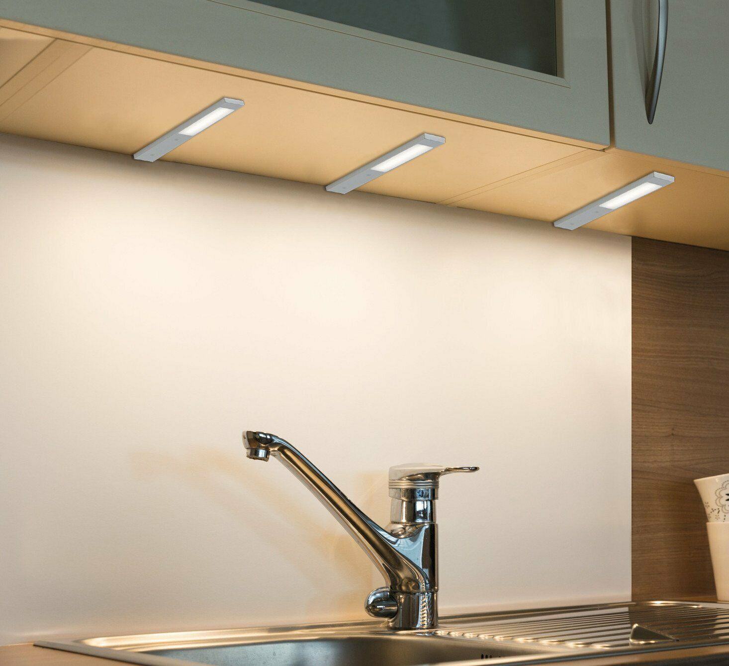 Eingeschaltete LED-Unterbauleuchte über Küchenspüle  warmweißes Licht