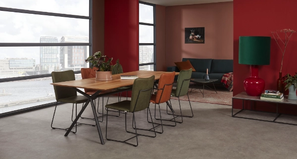 Esszimmer mit großem Holztisch, sechs Stühlen in Grün und Orange, moderner Einrichtung und Panoramafenstern mit Stadtblick.