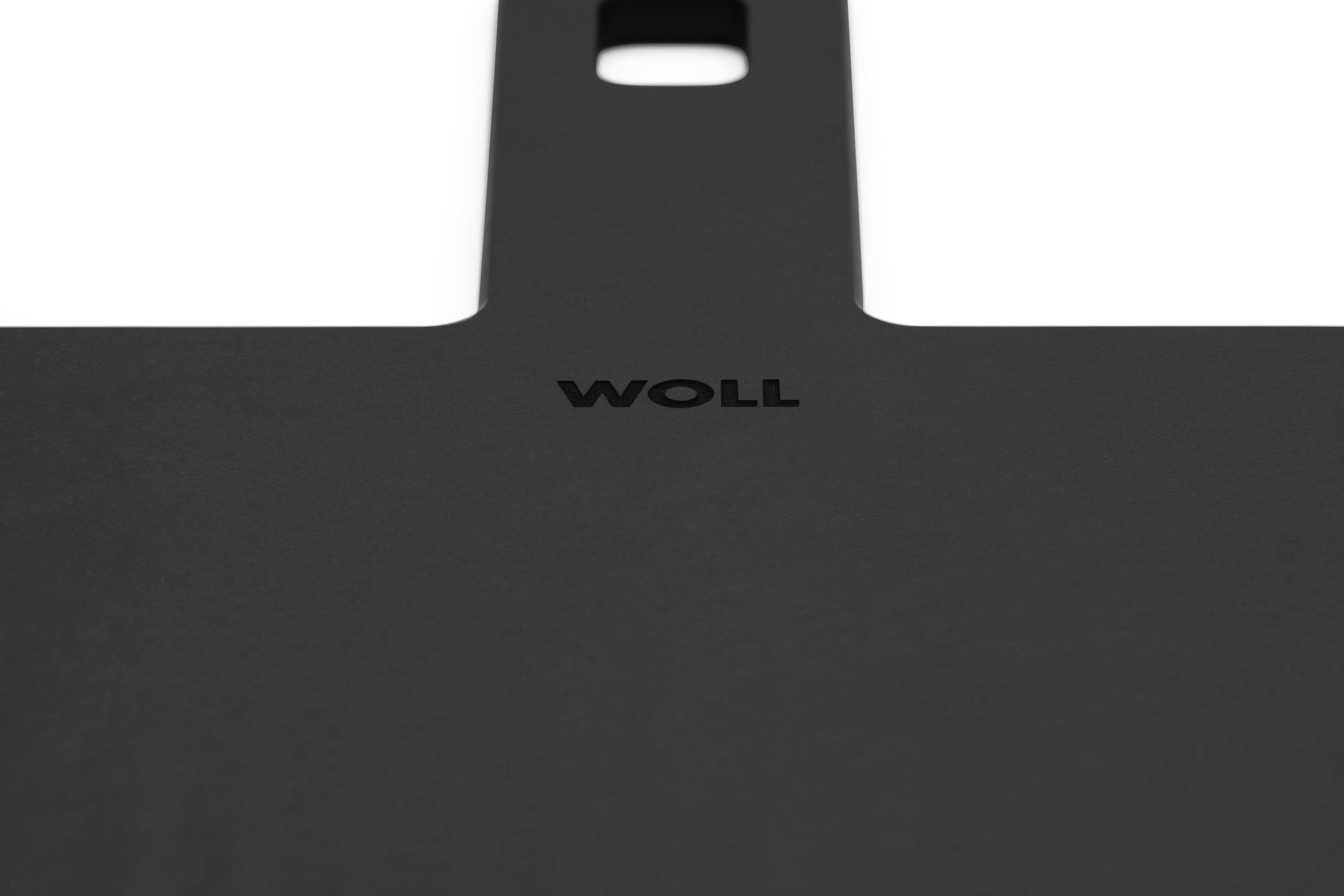 Schneidebrett "Cut & Serve" von WOLL Nahaufnahme von oben auf den oberen Teil eines schwarzen Schneidebretts mit sichtbarem WOLL-Schriftzug
