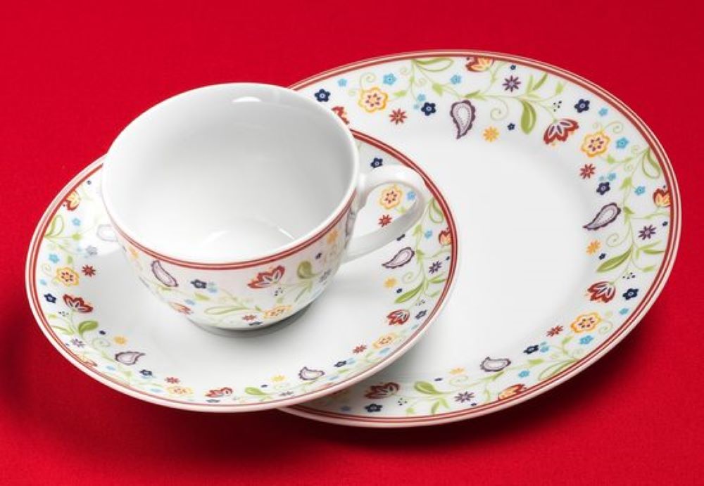 Service mit Blütenmuster und rotem Rand  bestehend aus Tasse  Untertasse und Teller  einzeln arrangiert
