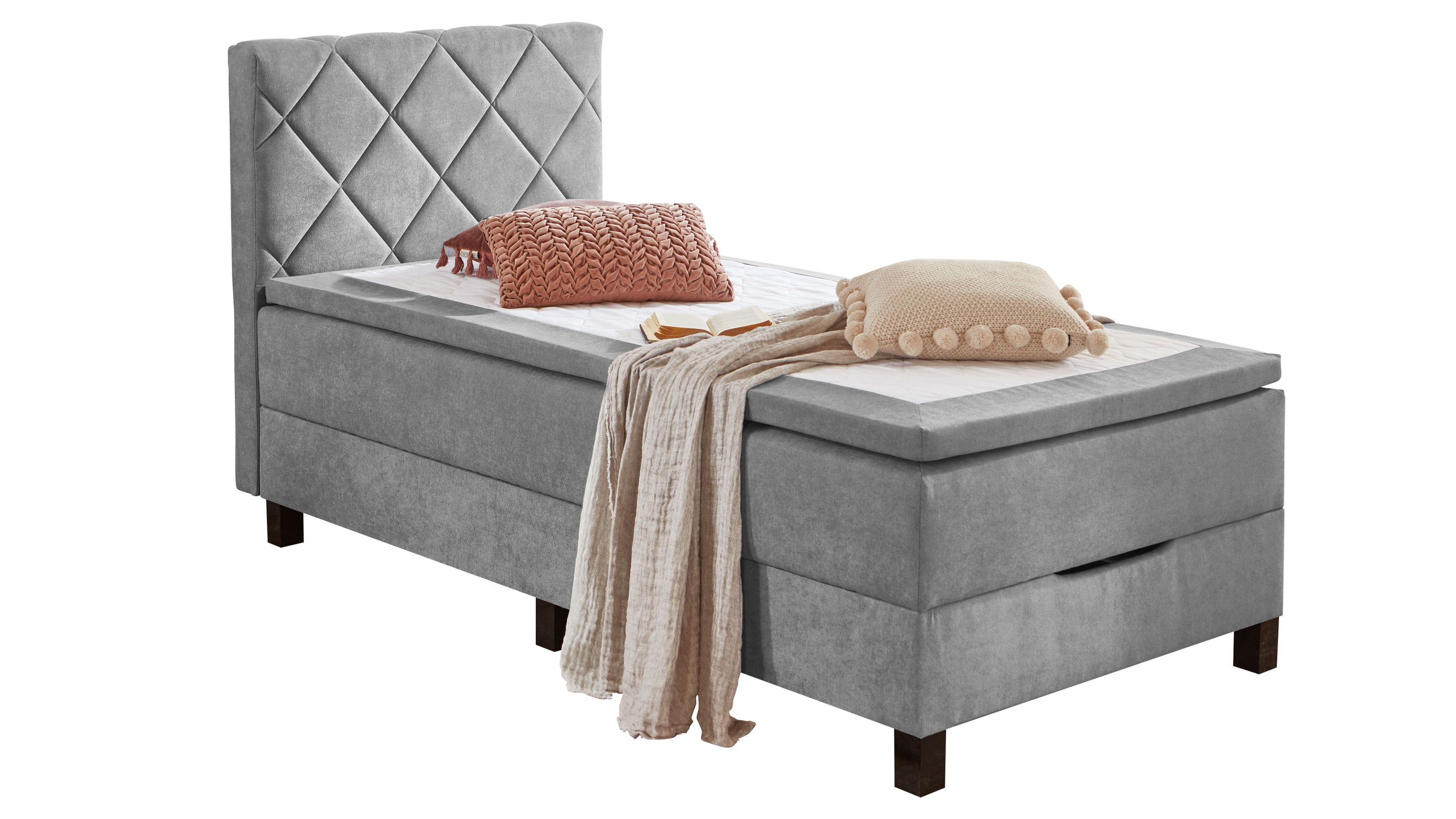 Boxspringbett mit silberfarbenem Bezug und gepolstertem Kopfteil Boxspringbett mit silberfarbenem Bezug gepolstertem Kopfteil mit Rautenmuster zwei Kissen und Decke