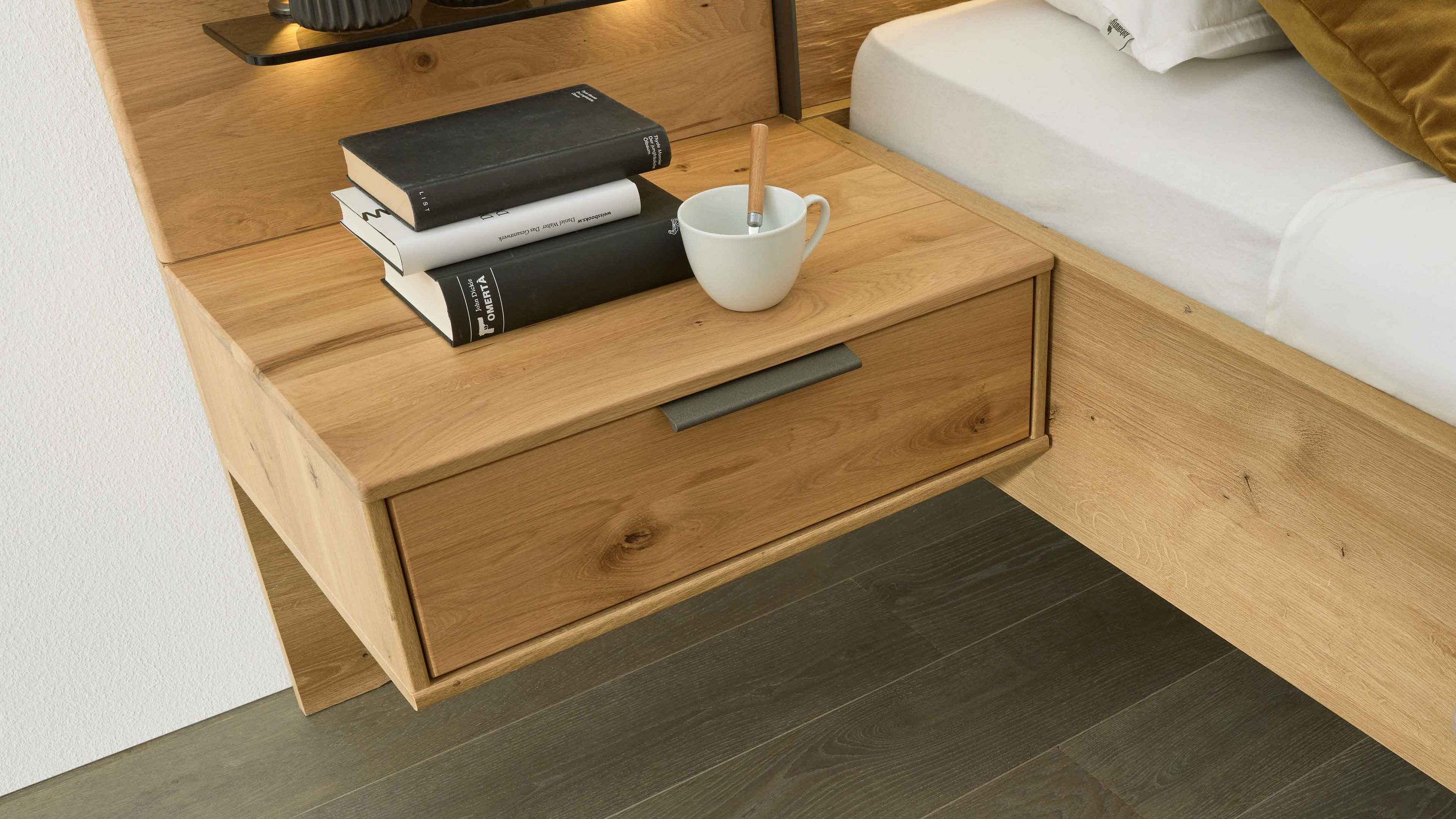 Zweiteiliges Nachtkonsolen-Set aus hellem Holz mit Schublade und Metallgriff neben einem Bett