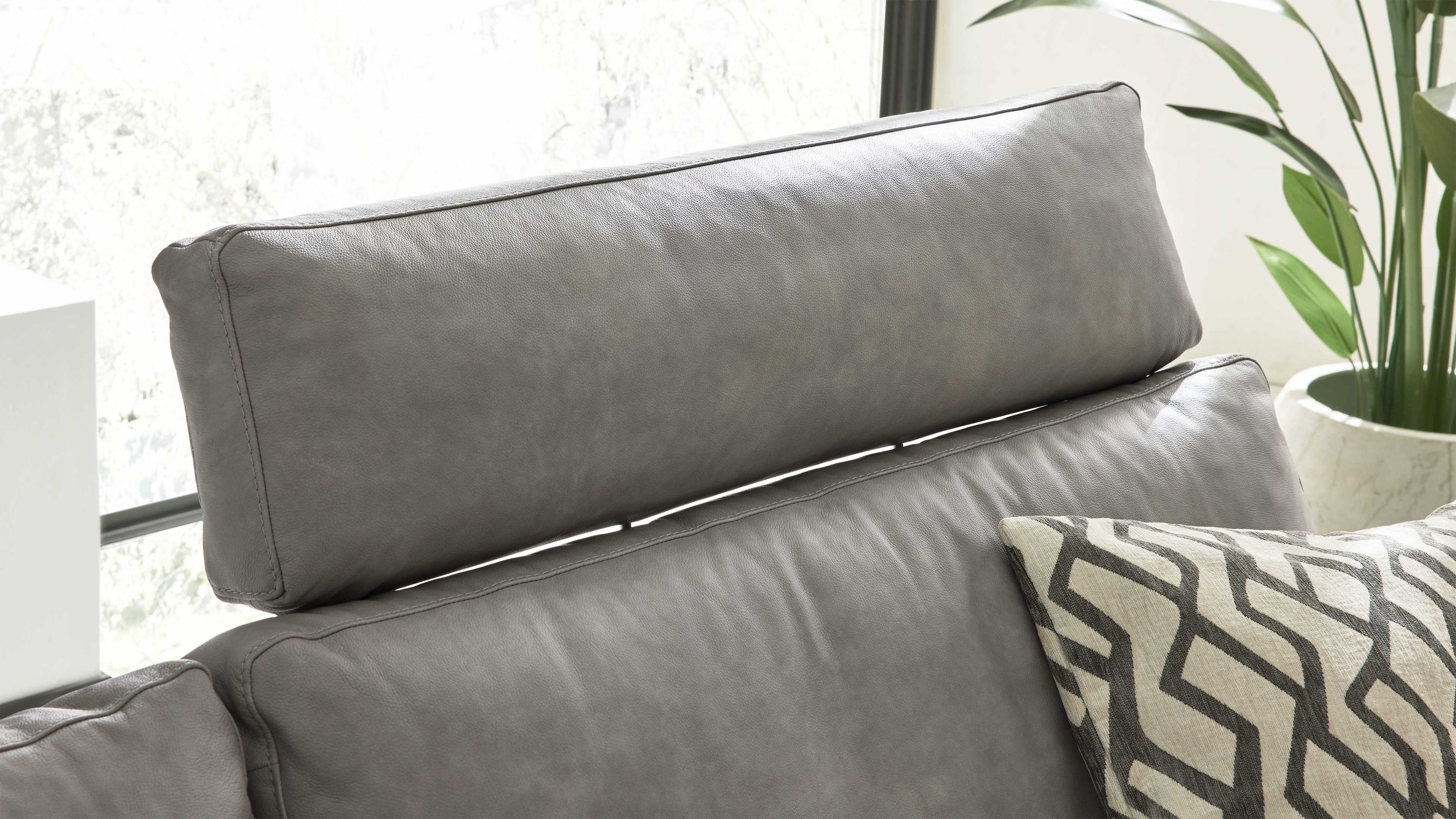 Hellgraue Kopfstütze mit rechteckiger Form und weichem Polster auf einem Sofa