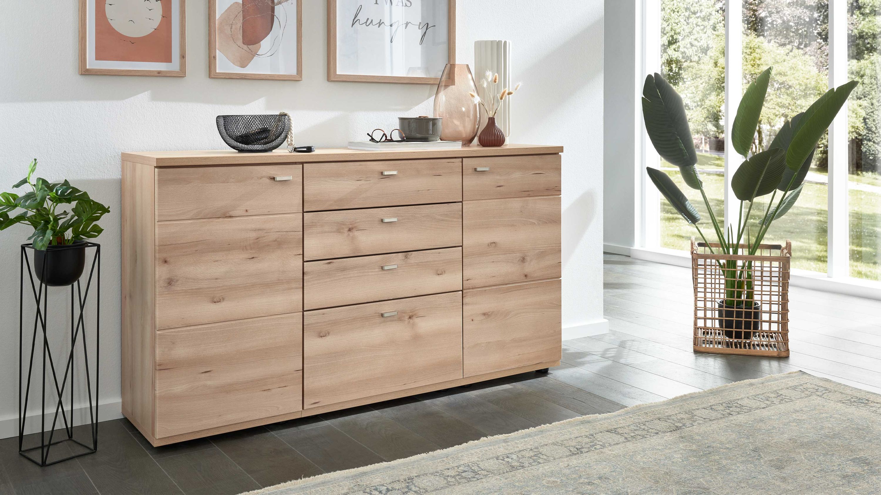 Sideboard mit zwei Türen und vier Schubladen in heller Holzoptik in einem Wohnzimmer