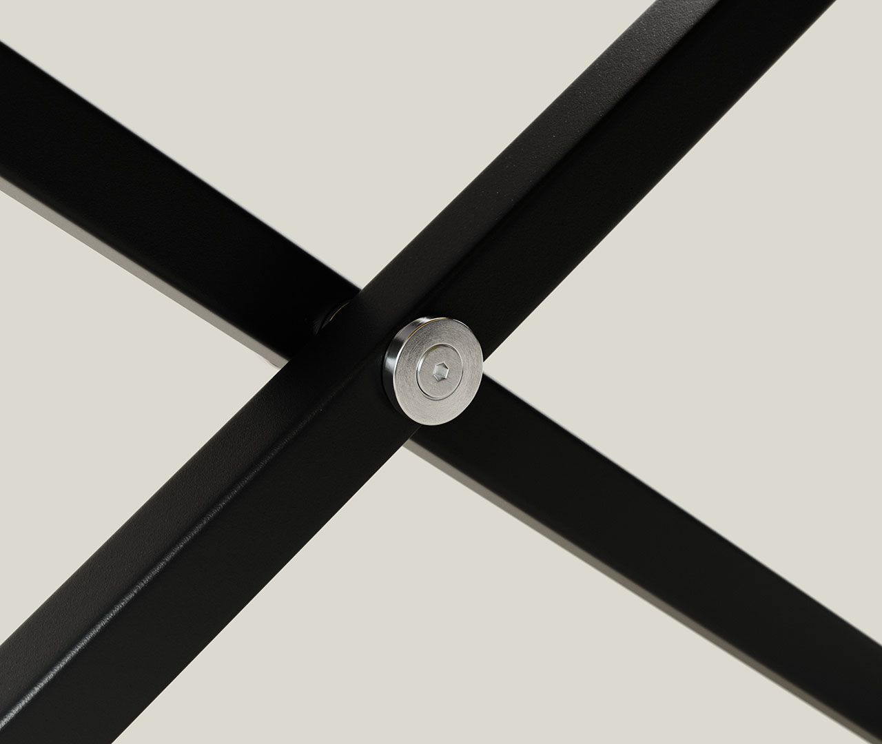 Detailansicht der Kreuzung zweier schwarzer Metallstreben mit silberner Achse am höhenverstellbaren Schreibtisch.