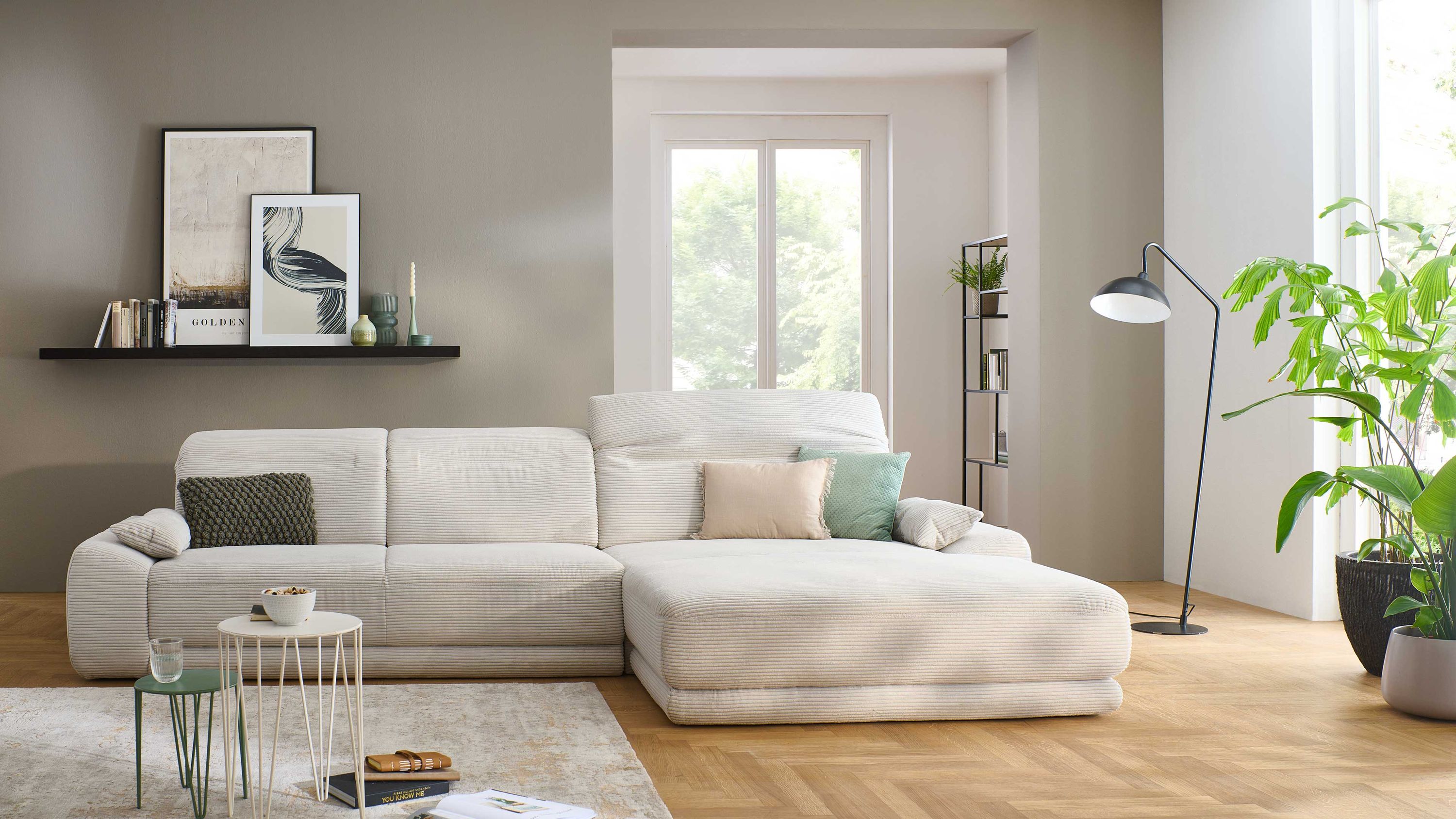 Hellgraues Ecksofa mit verstellbaren Kopfstützen und breitem Cordbezug in modernem Wohnzimmer