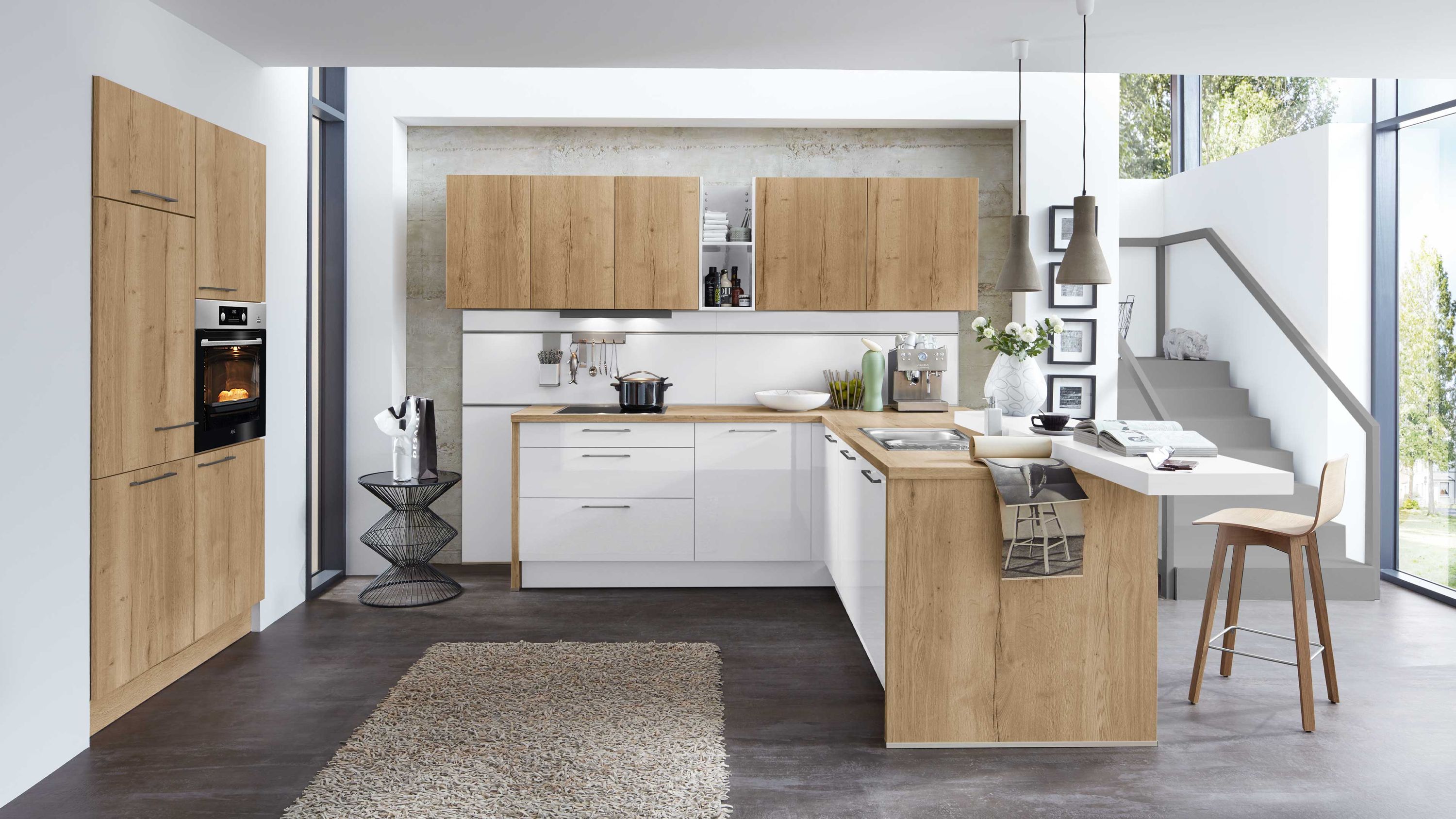 L-Küche in Weiß und Holzoptik mit Theke. Zweifarbige L-Küche in Weiß und Holzoptik mit Theke Einbauofen Hängeschränken und modernem Treppenaufgang.