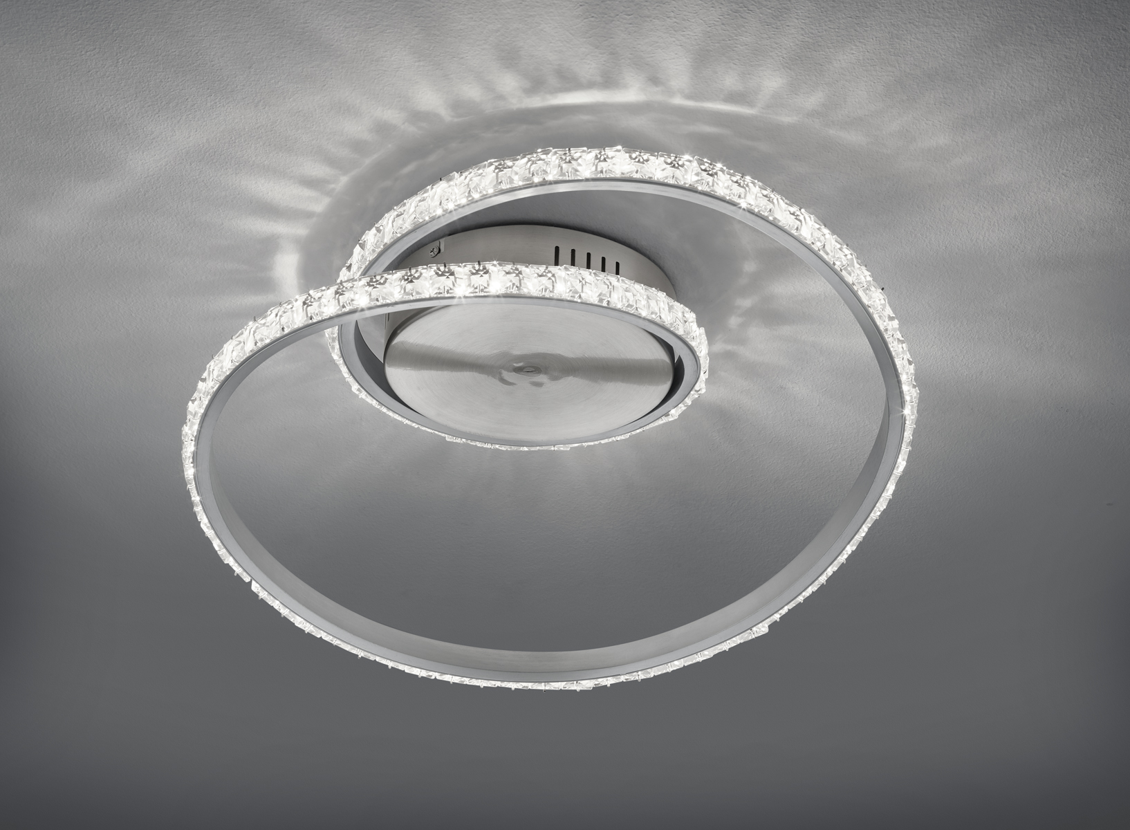 Moderne Deckenleuchte mit spiralförmigem LED-Design und Farbwechsel-Funktion; von unten leicht nach oben fotografiert