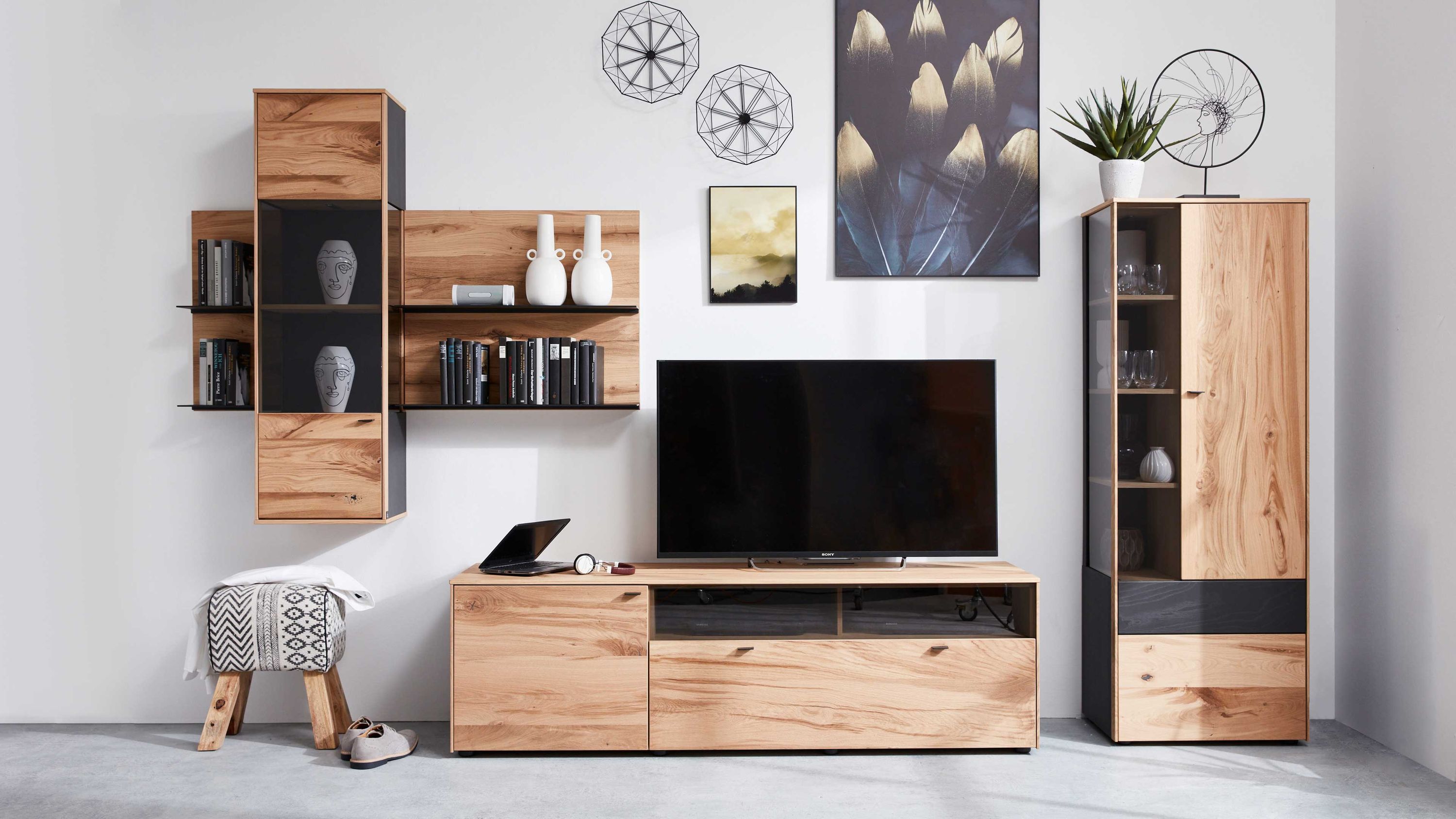 Fünfteilige Wohnwand mit Holz und anthrazitfarbenen Elementen Fünfteilige Wohnwand aus Holz mit anthrazitfarbenen Elementen bestehend aus Vitrine TV-Board und Wandregalen