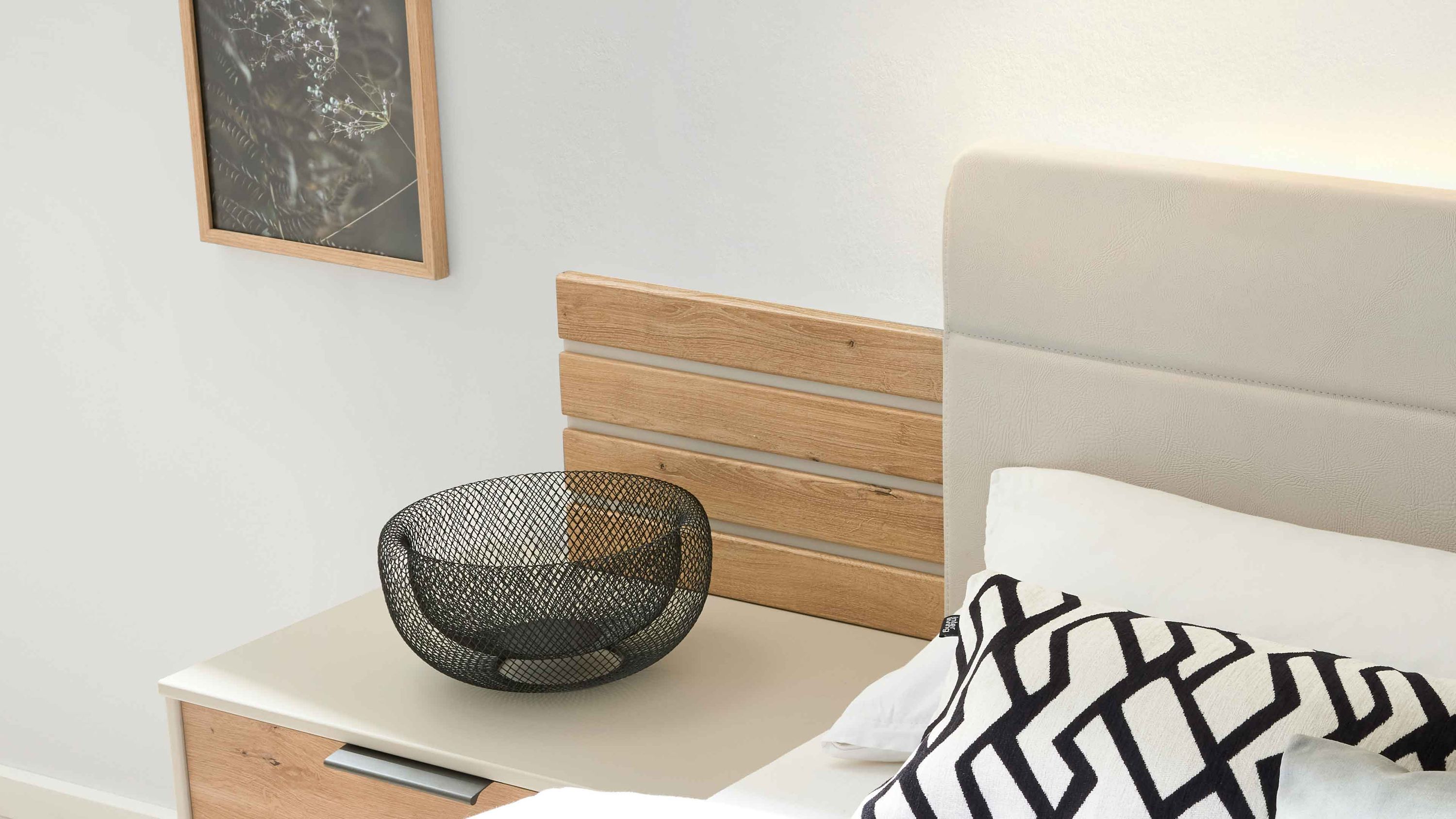 Zweiteiliges Paneel-Set aus Holz mit horizontalen Lamellen in hellem Braun neben einem weißen gepolsterten Kopfteil