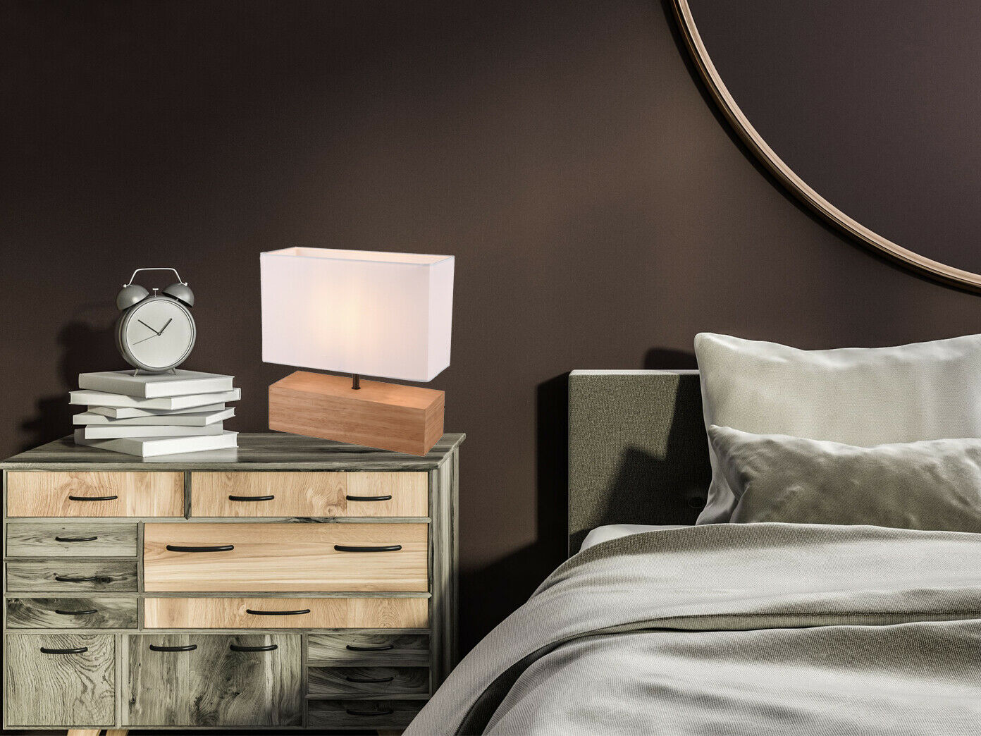 Tischlampe mit Holzfuß textilschirm beleuchtet Tischleuchte mit weißem Textilschirm und braunem Holzsockel auf hellem Sideboard vor brauner Wand neben Bett, Licht an