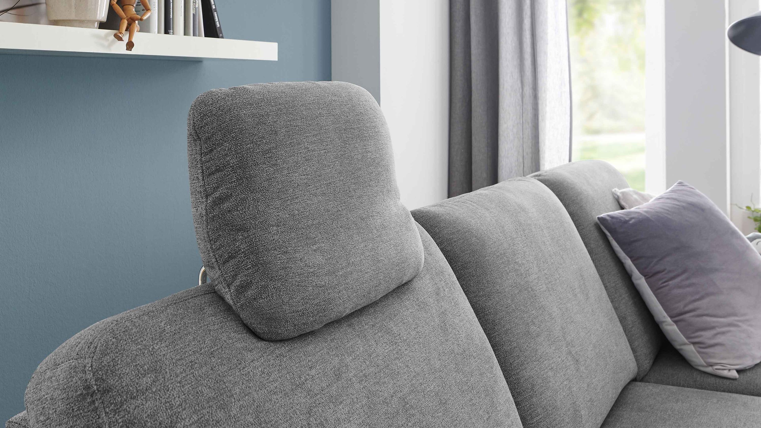 Graue Kopfstütze auf grauem Sofa mit Kissen im Wohnzimmer