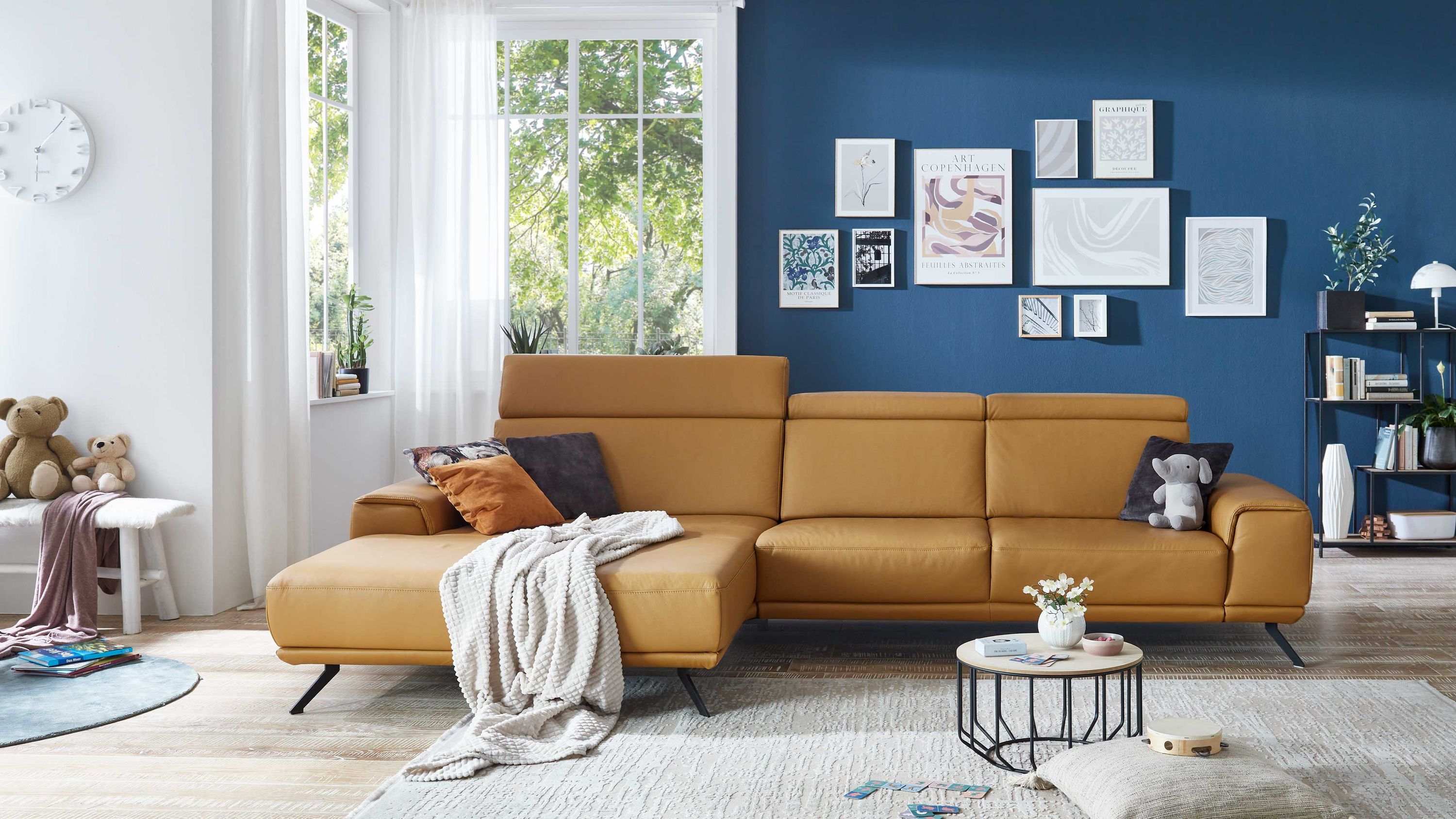 Ecksofa mit kurkumafarbenem Lederbezug und schwarzen Metallfüßen in modernem Wohnzimmer