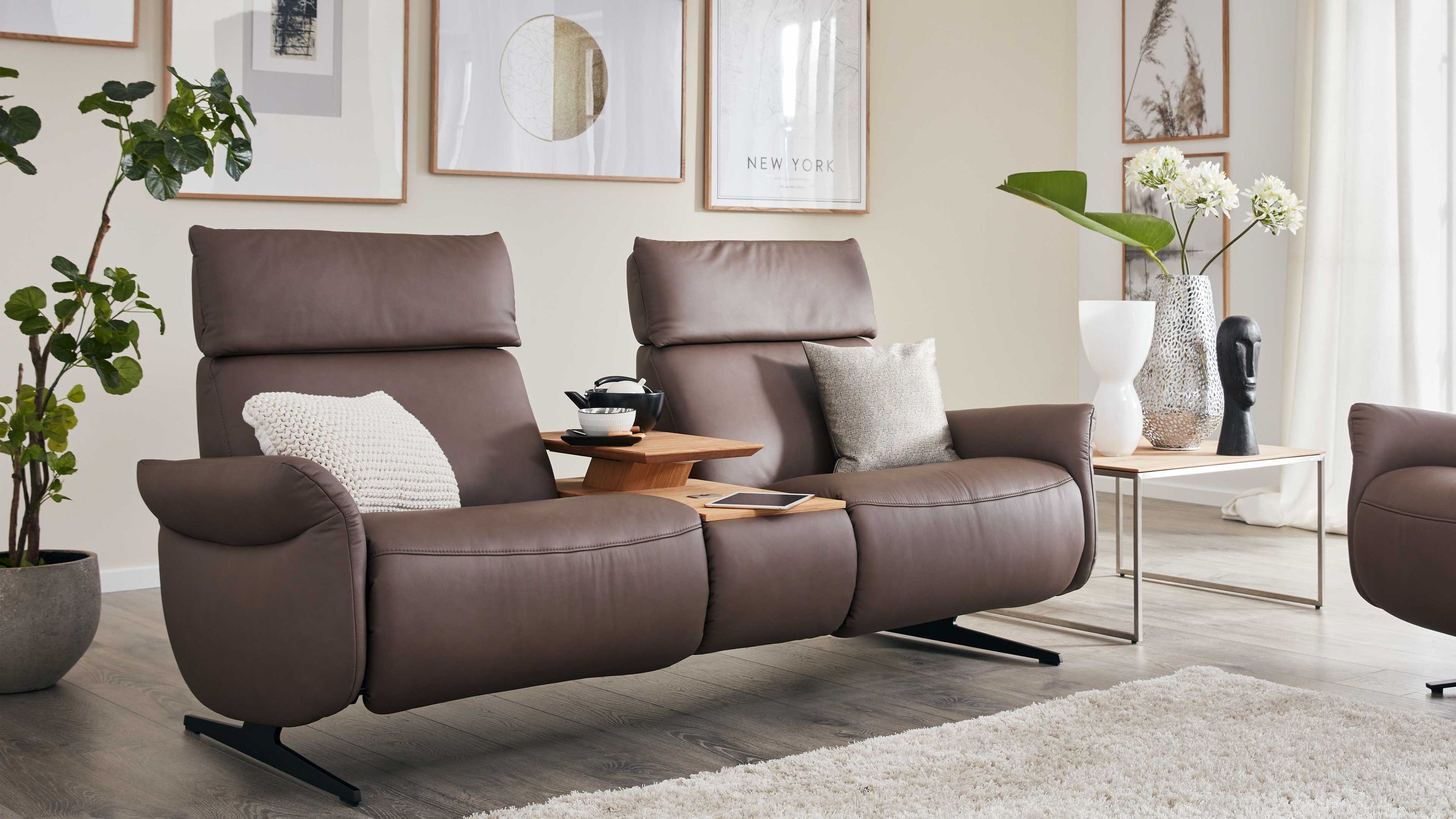 Zweisitziges Ledersofa mit Holzablagen Zweisitziges Sofa mit hohen Rückenlehnen und Armlehnen in braunem Leder mit zwei Kissen und Holzablagen