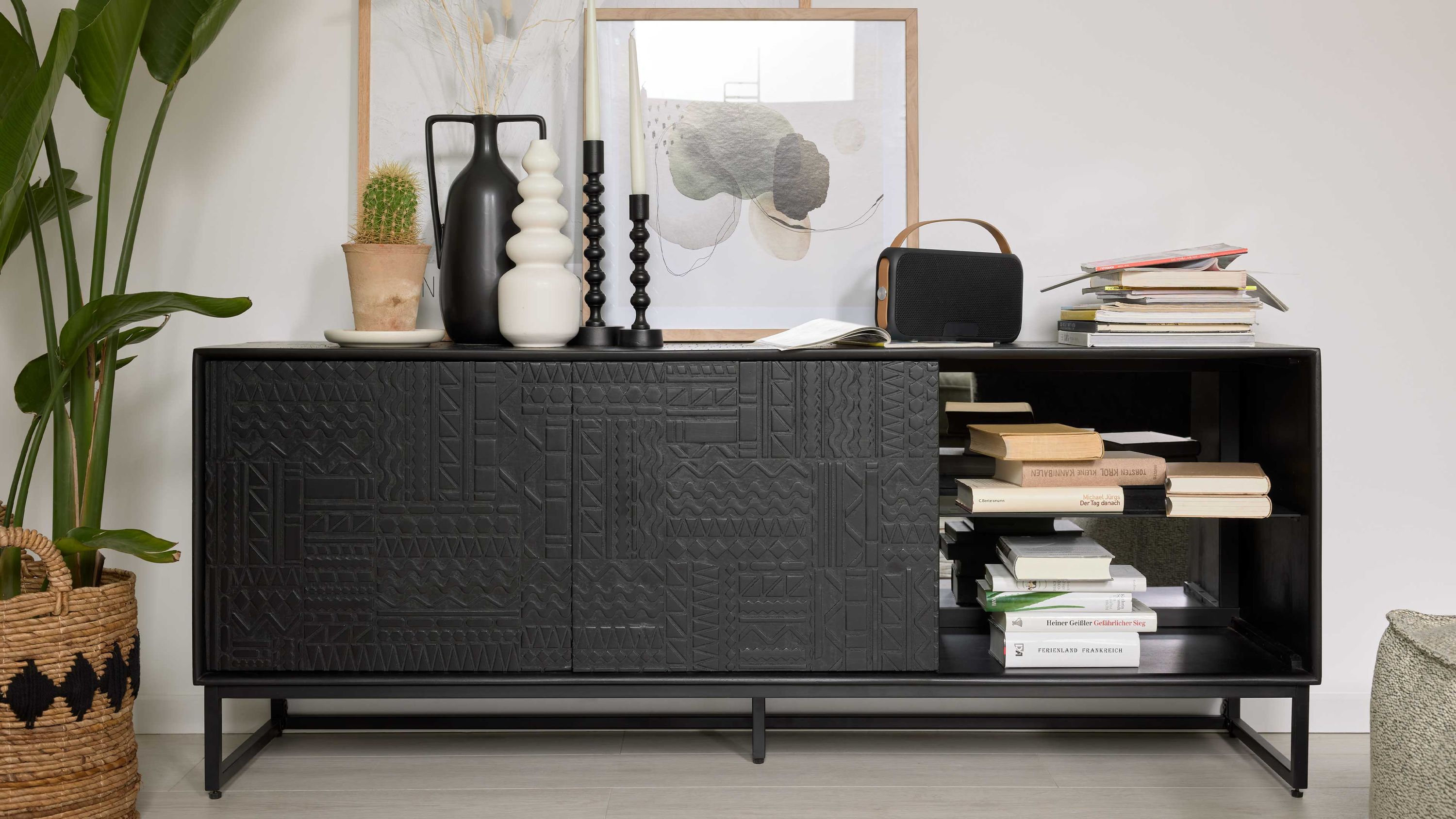 Schwarzes Lowboard mit zwei Türen und offenem Fach Schwarzes Lowboard mit zwei Türen und offenem Fach dekorative Muster auf den Türen Metallgestell