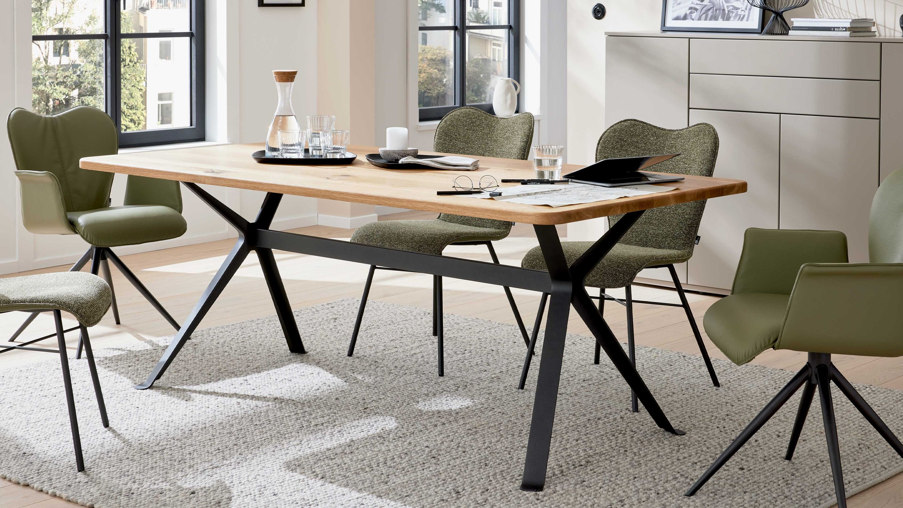 Rechteckiger Esstisch mit hellholzfarbener Tischplatte und schwarzem Metallgestell in modernem Esszimmer