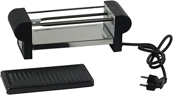Schwarzes Raclette-Set mit Grillplatte  zwei Pfännchen und Zubehör in kompakter Anordnung auf heller Fläche