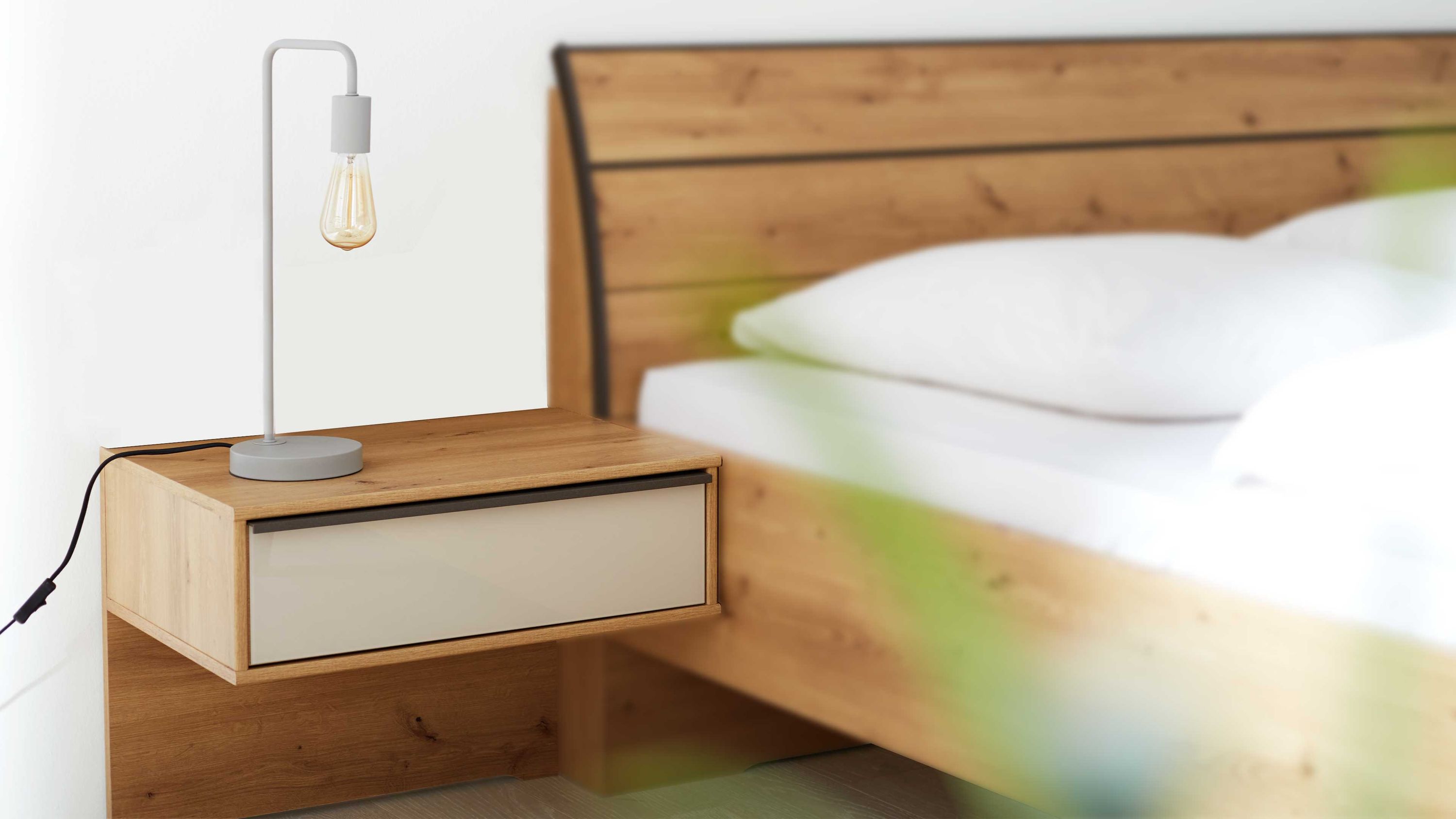 Zweiteiliges Nachtkonsolen-Set mit rechteckiger Form Holzoptik und einer hellen Schublade neben einem Bett